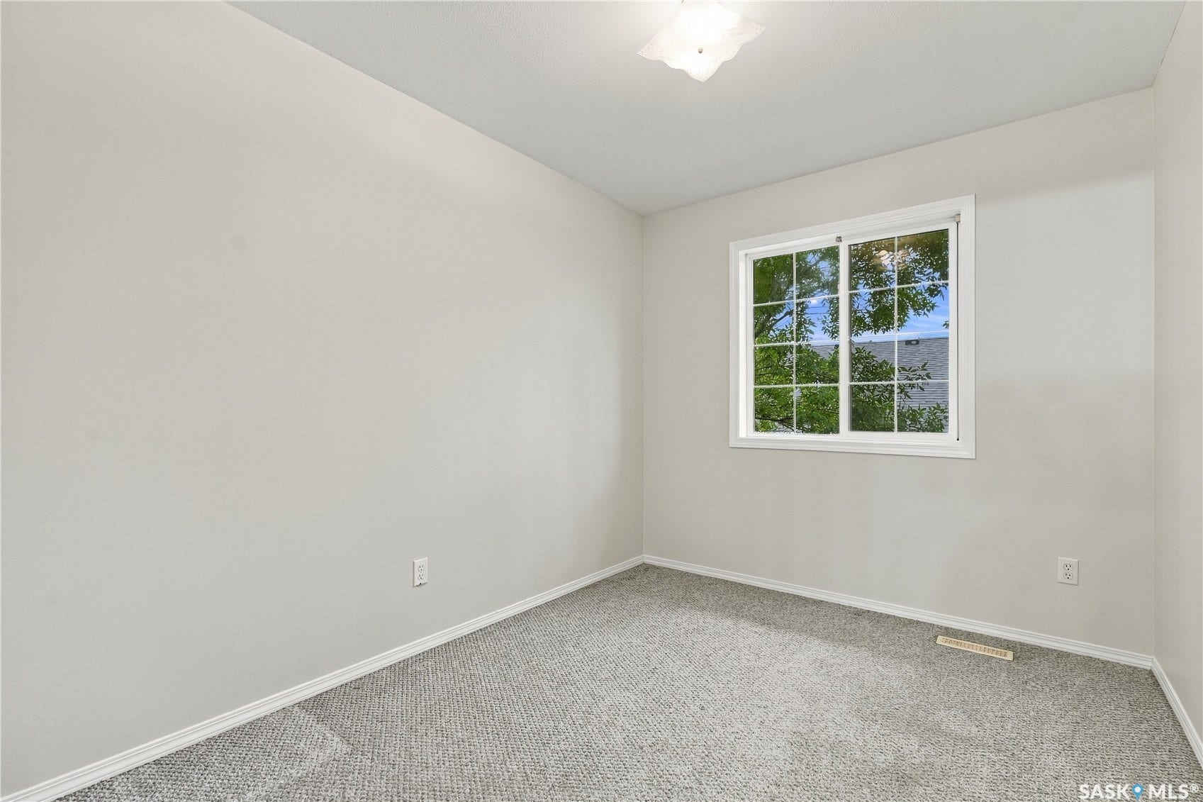 Neutral wall tones, gray carpet flooring, white trim, and a white-framed window