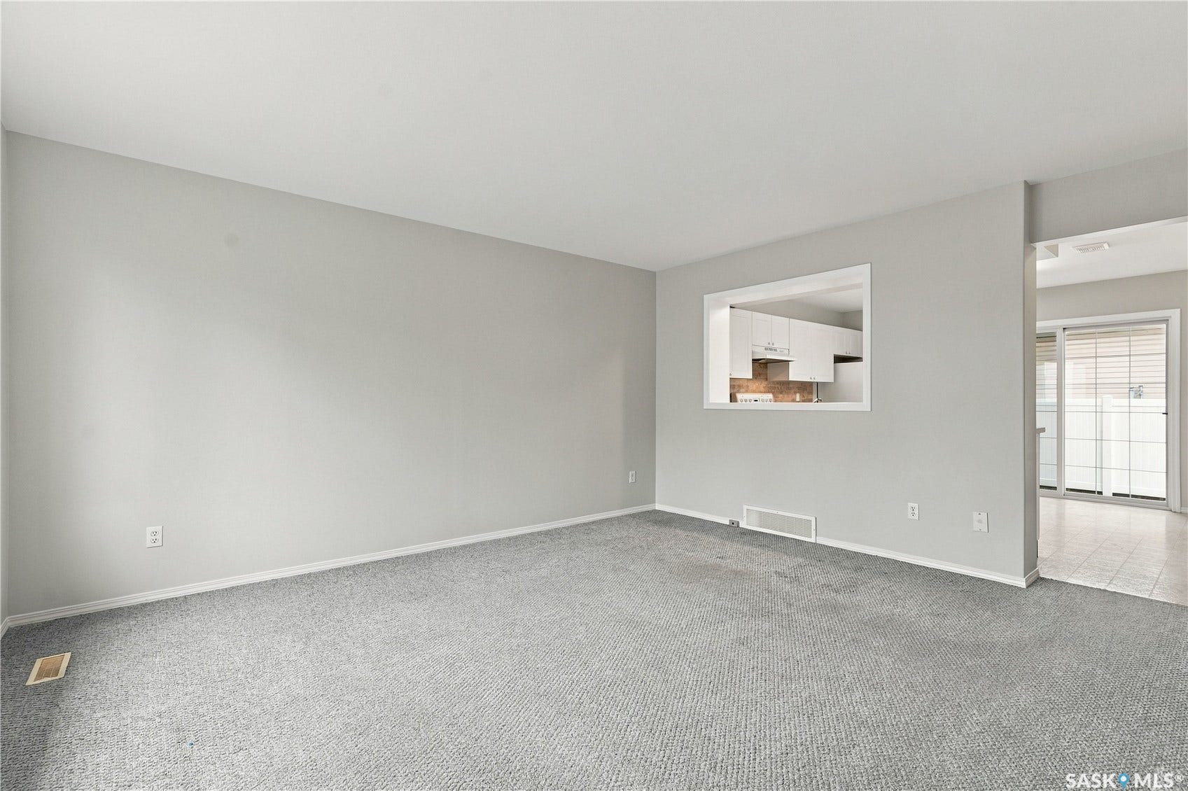 Expansive room with neutral carpeting and light-toned walls