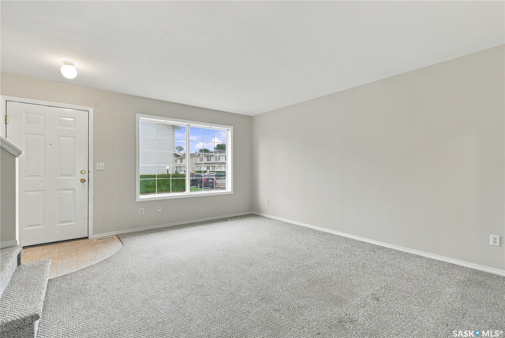Entry area with light gray wall paint and matching carpet flooring