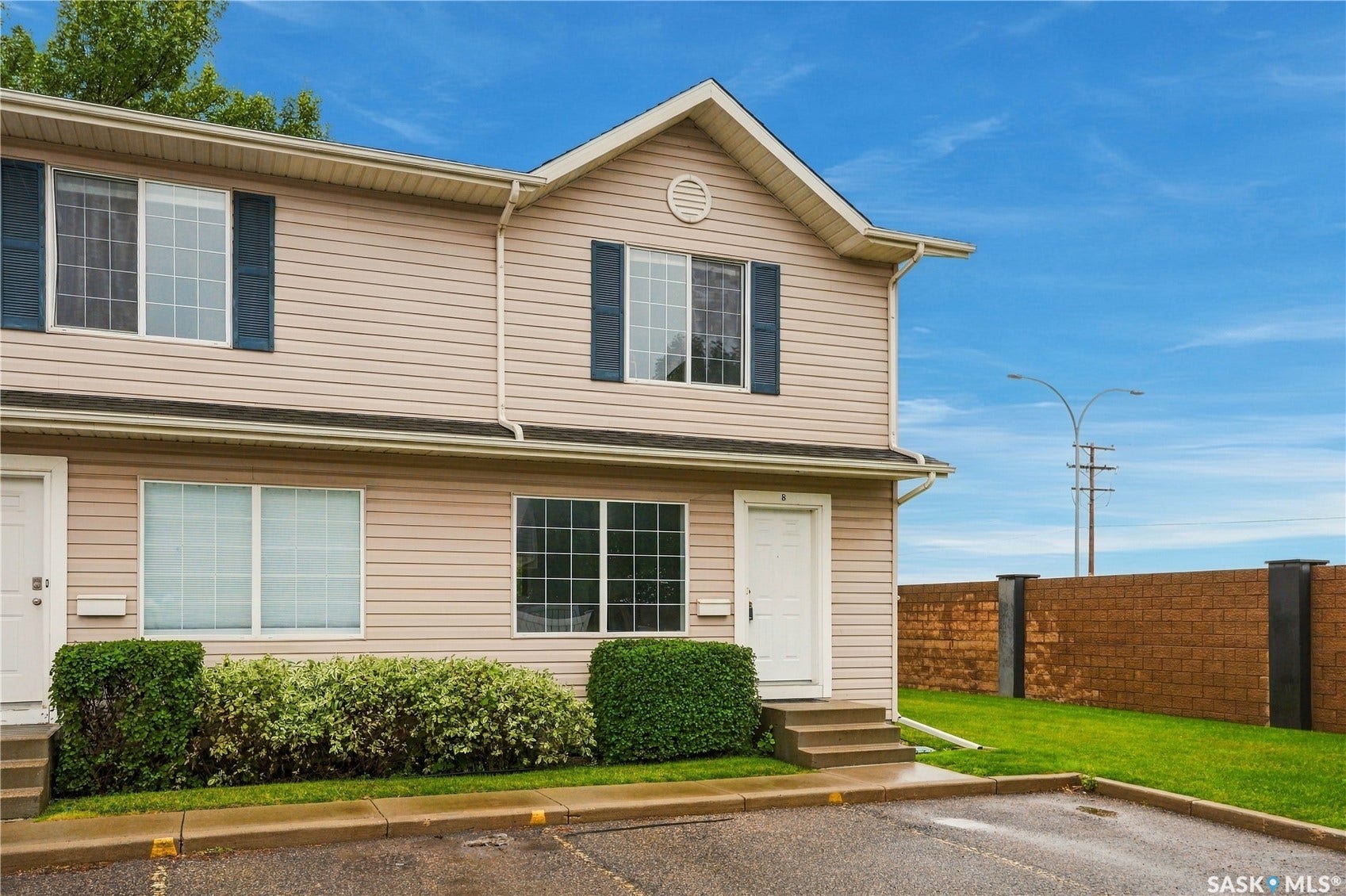 Two-story residence featuring light-colored siding and dark shutters