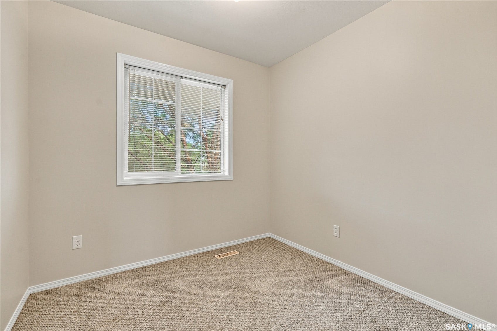Neutral wall paint, carpet flooring, window with blinds, and white trim