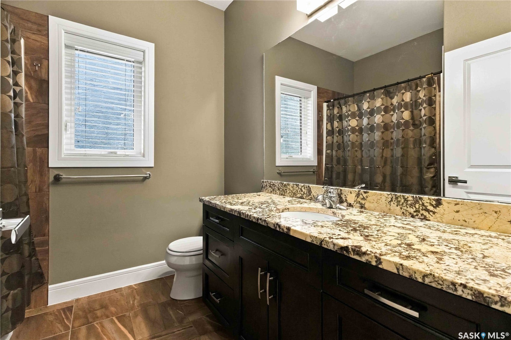 Spacious vanity with a stone countertop and an undermount sink