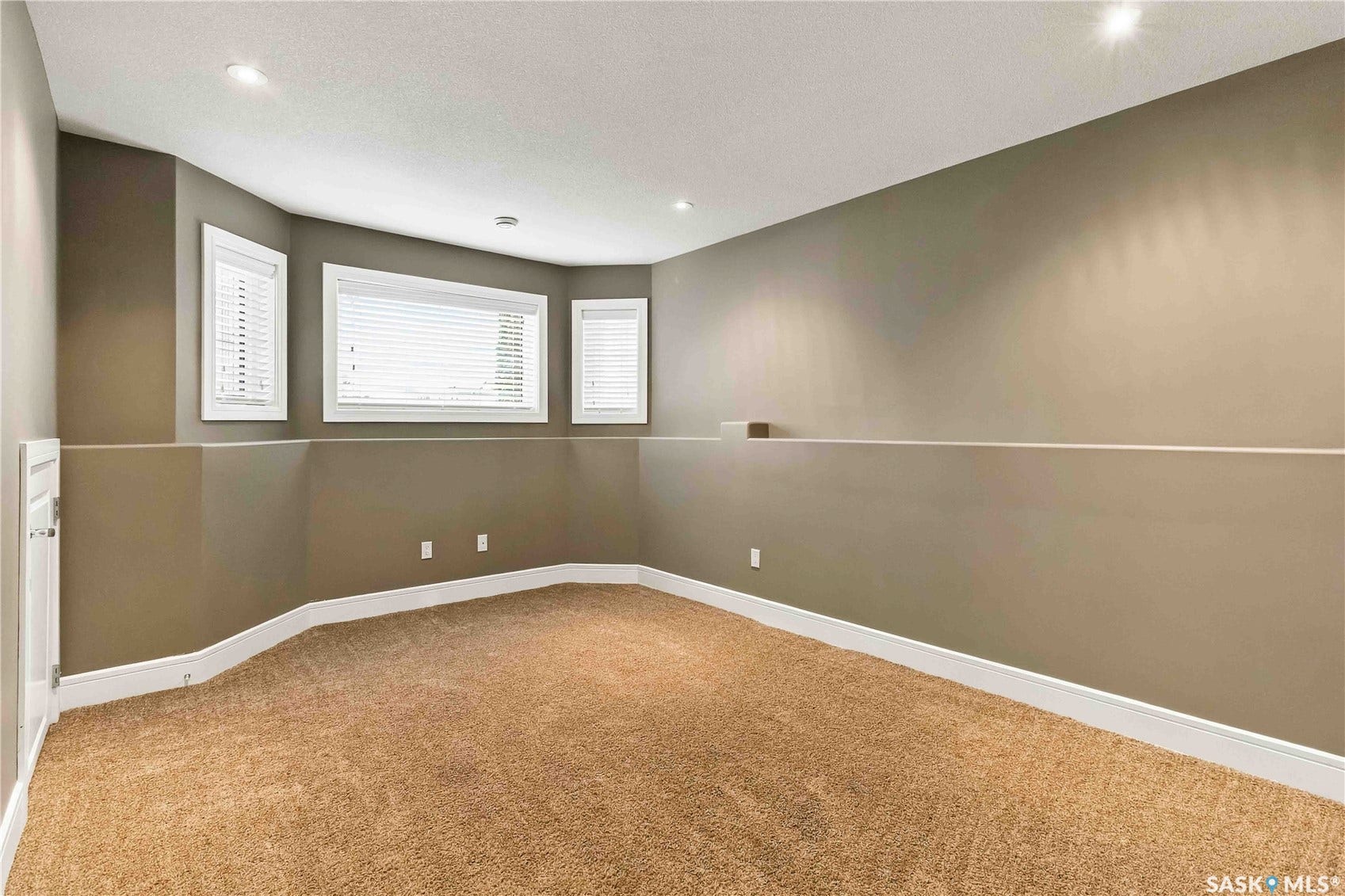 Recessed lighting, carpet flooring, multiple windows with blinds, two-tone wall treatment, and white trim