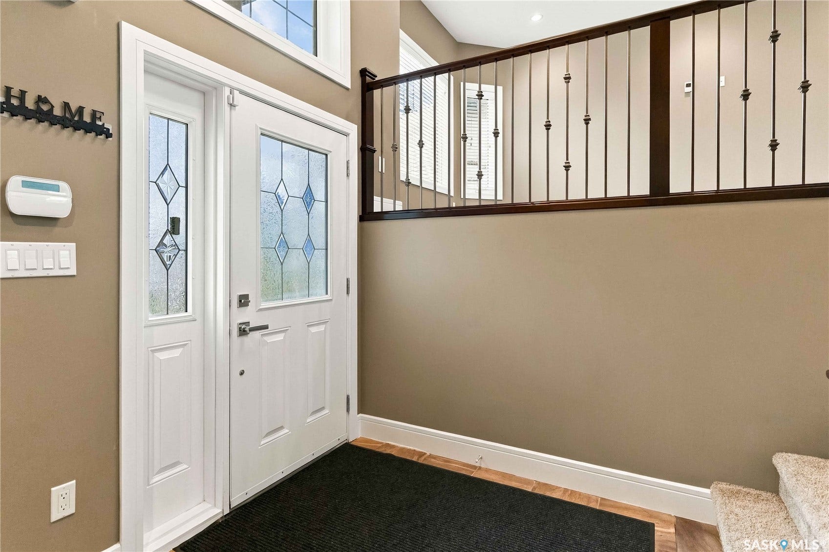 Entryway featuring a white door with decorative glass, an accompanying sidelight, and wood-finish flooring