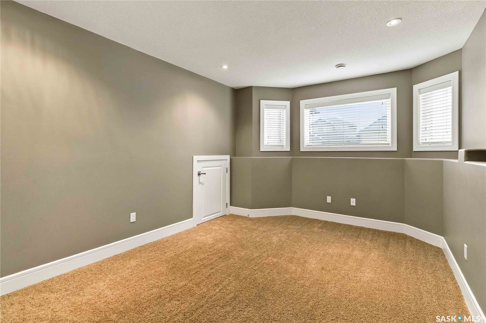 Recessed lighting, plush carpet flooring, bay window with blinds, neutral wall tones, and white trim