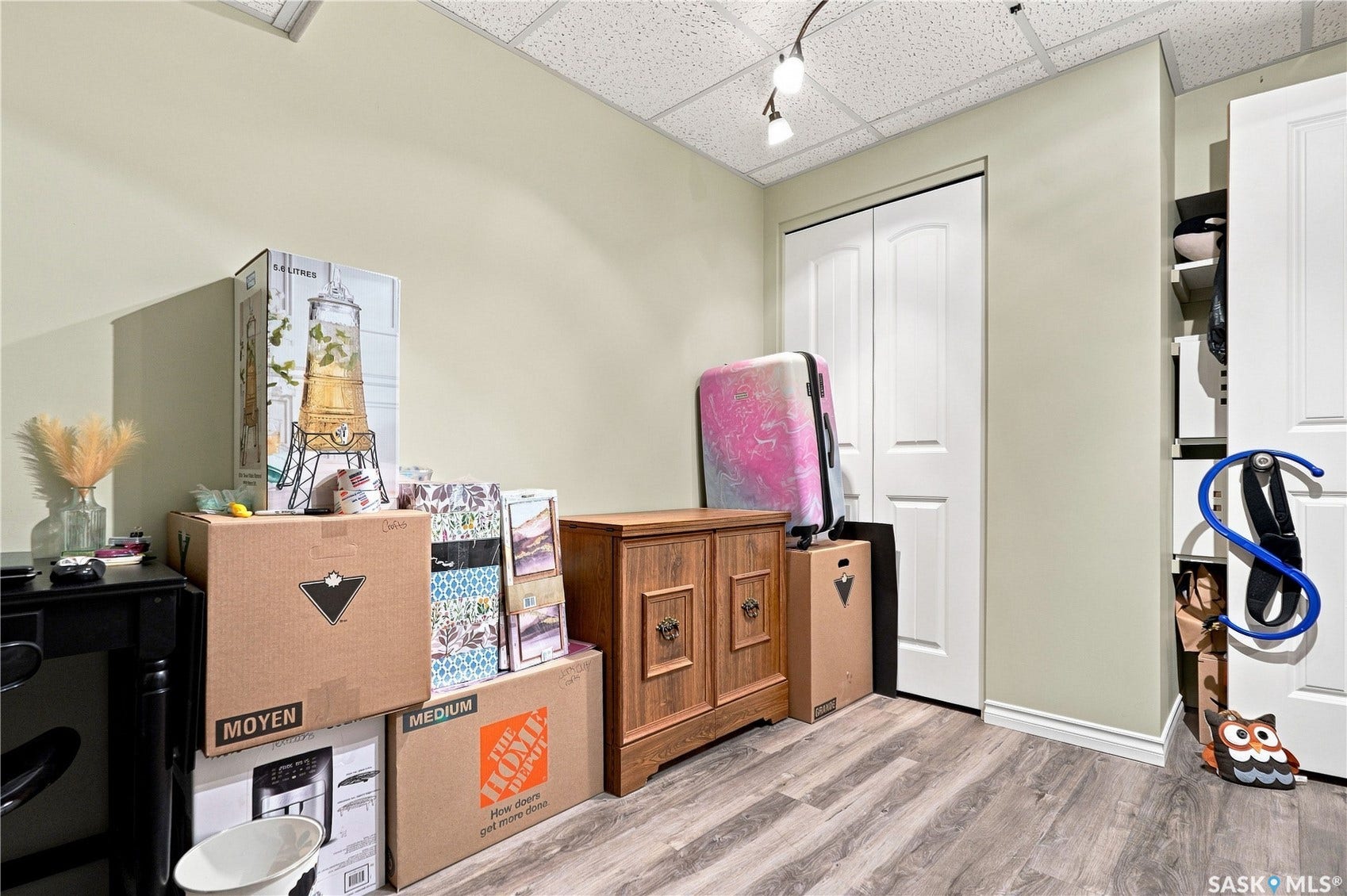 Wood-finish flooring with neutral wall paint and a drop ceiling