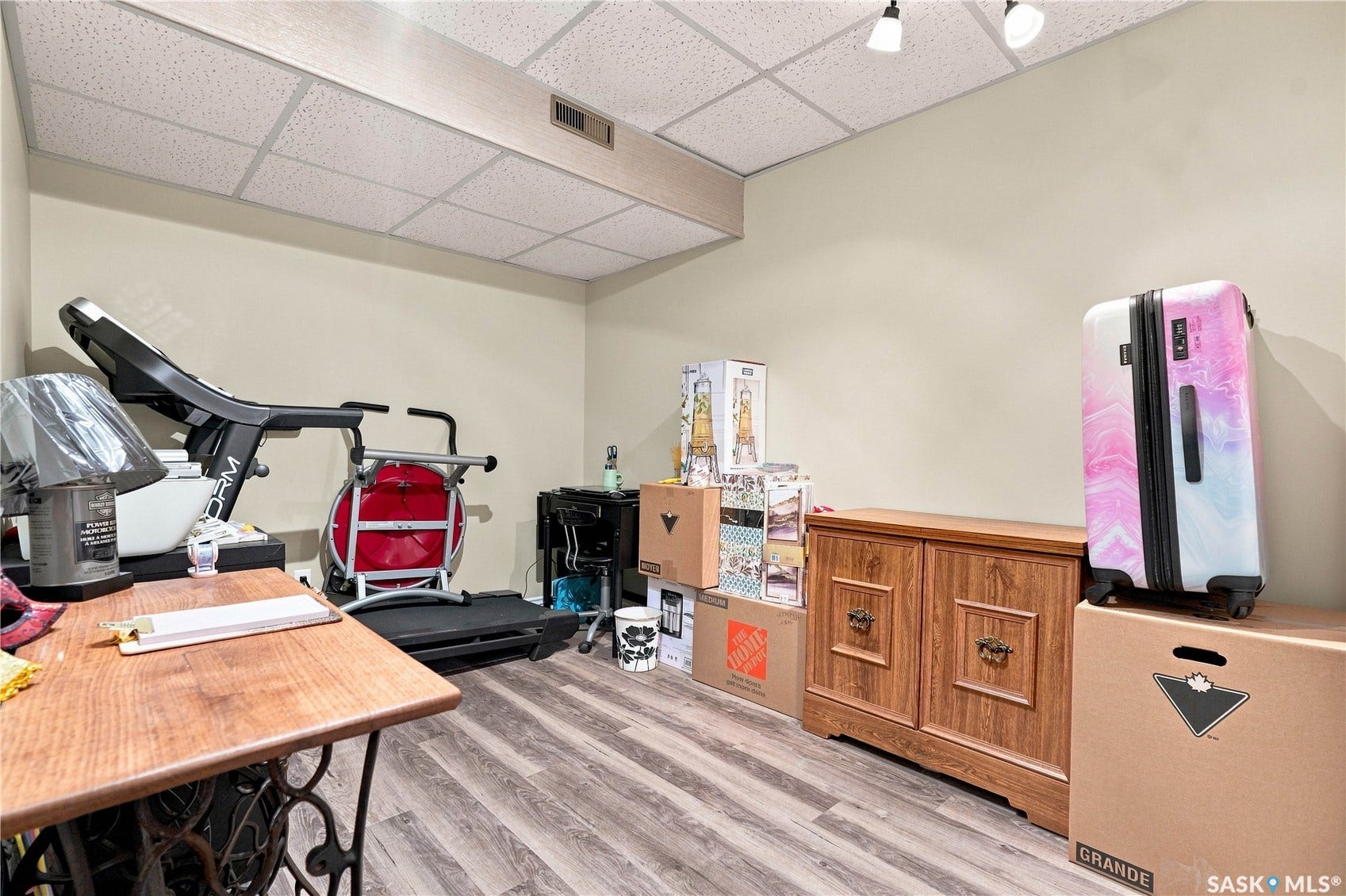 Wood-finish flooring with neutral wall paint and a drop ceiling