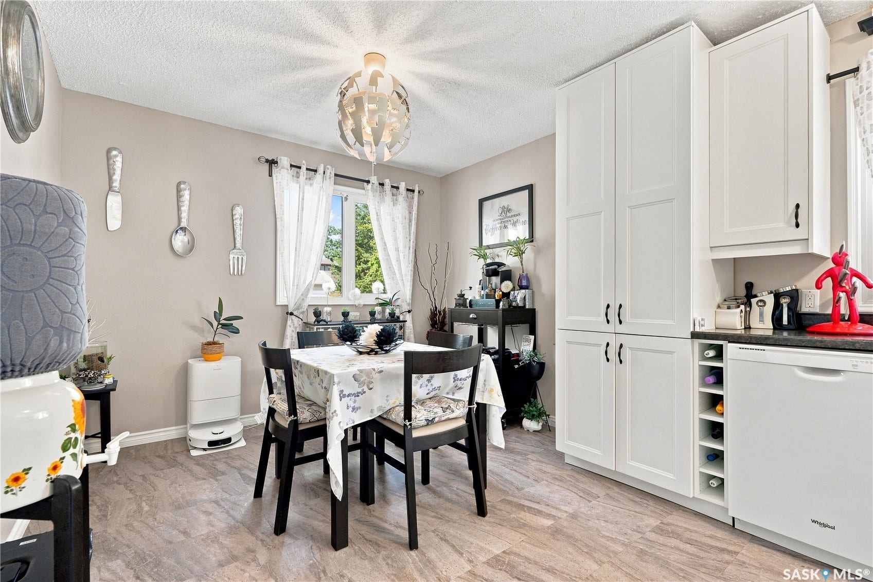White shaker-style cabinetry with black hardware, built-in wine rack, and a coordinating white dishwasher