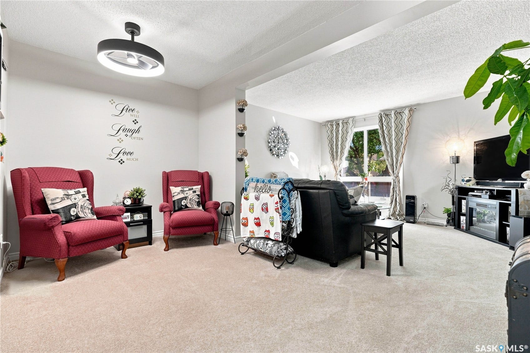 Recessed lighting, light neutral-toned carpet, and a large window with natural light