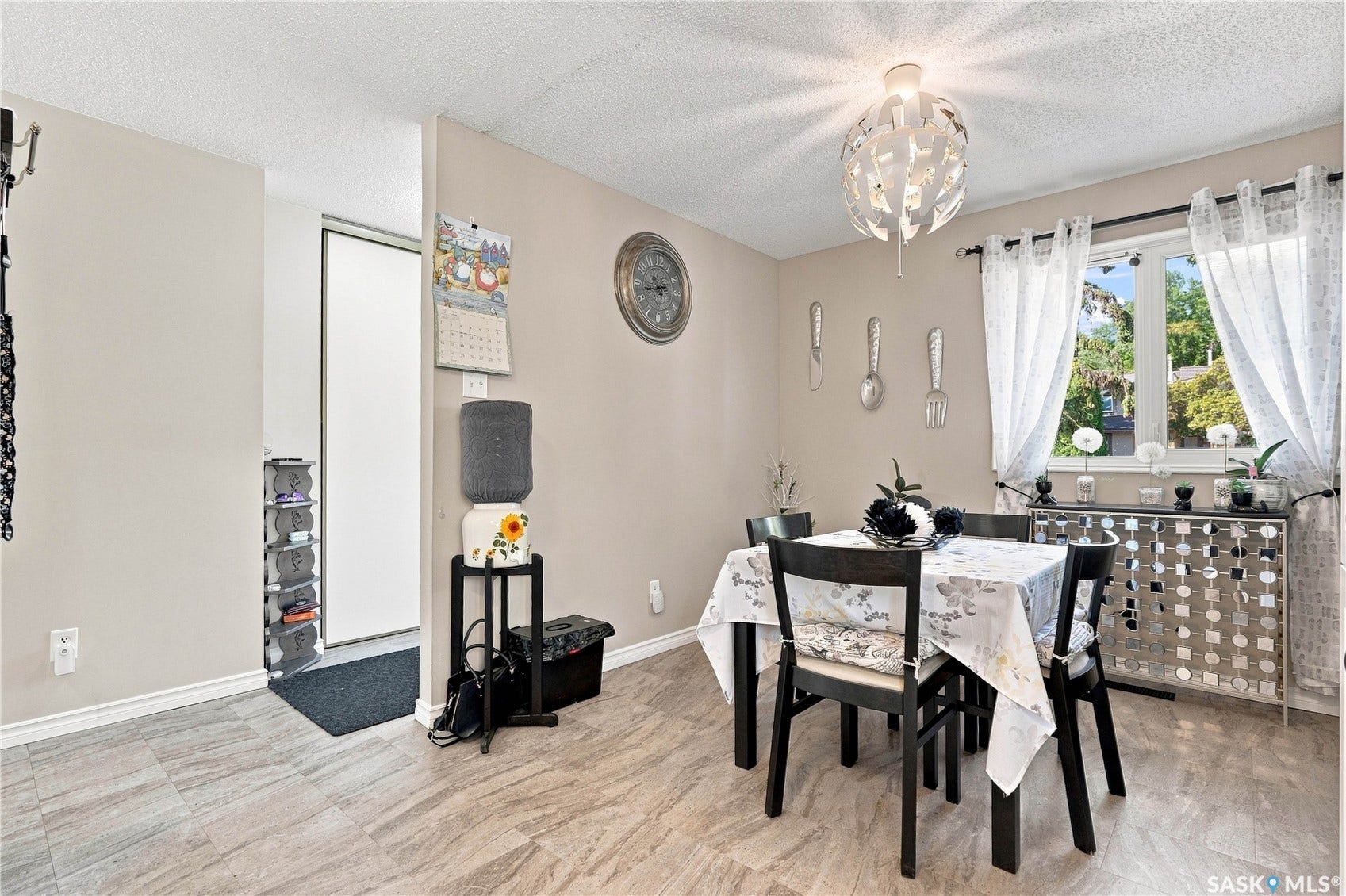 Light flooring throughout, modern lighting fixture, and a window with natural light