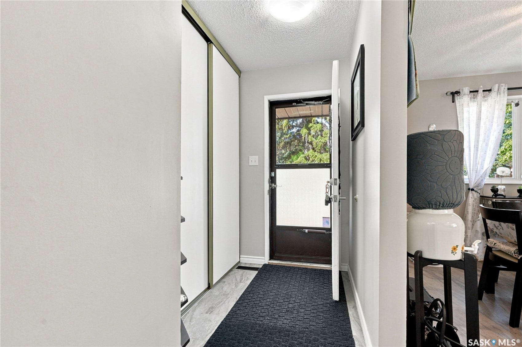 Entryway featuring a dark entry door with a storm door, and a flush mount ceiling light