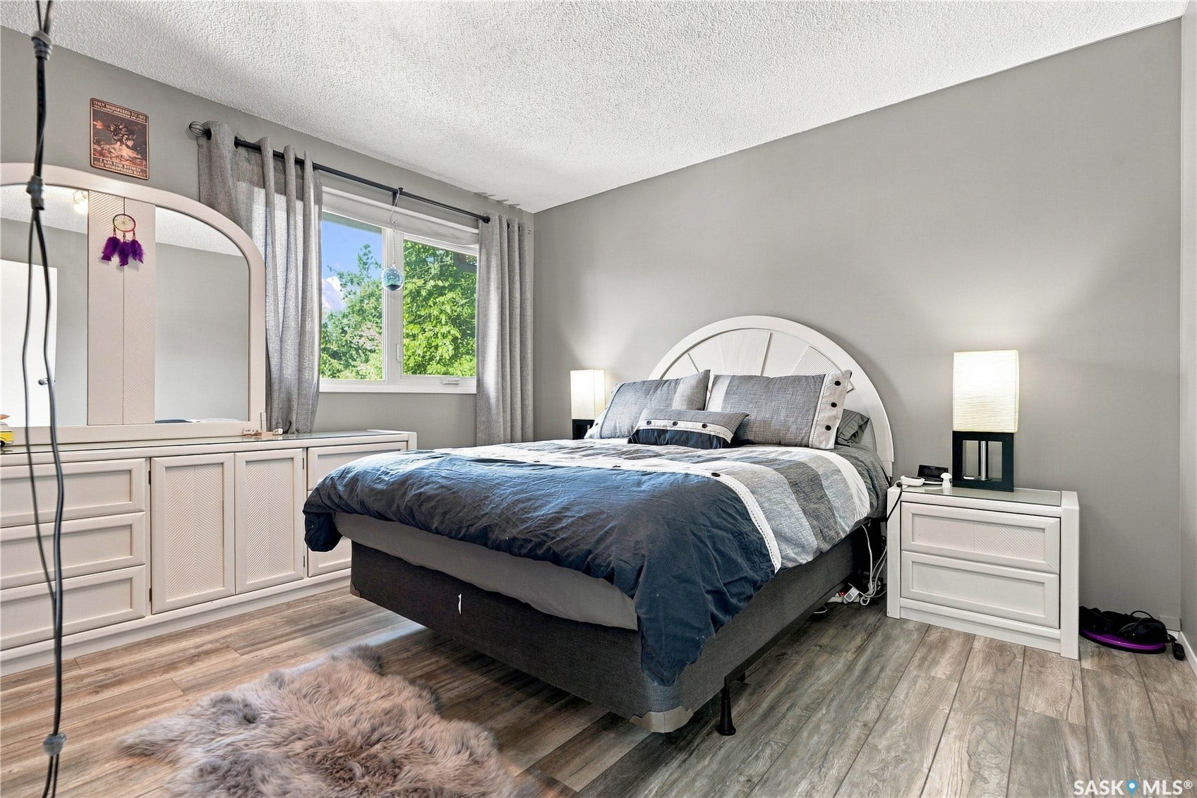 Wood-finish flooring, neutral wall paint, white trim, and a window with natural light