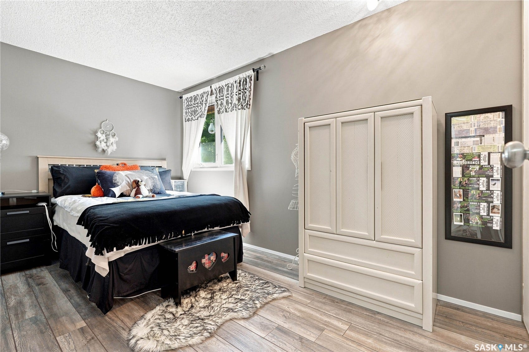 Wood-finish flooring with neutral wall tones and a window with natural light