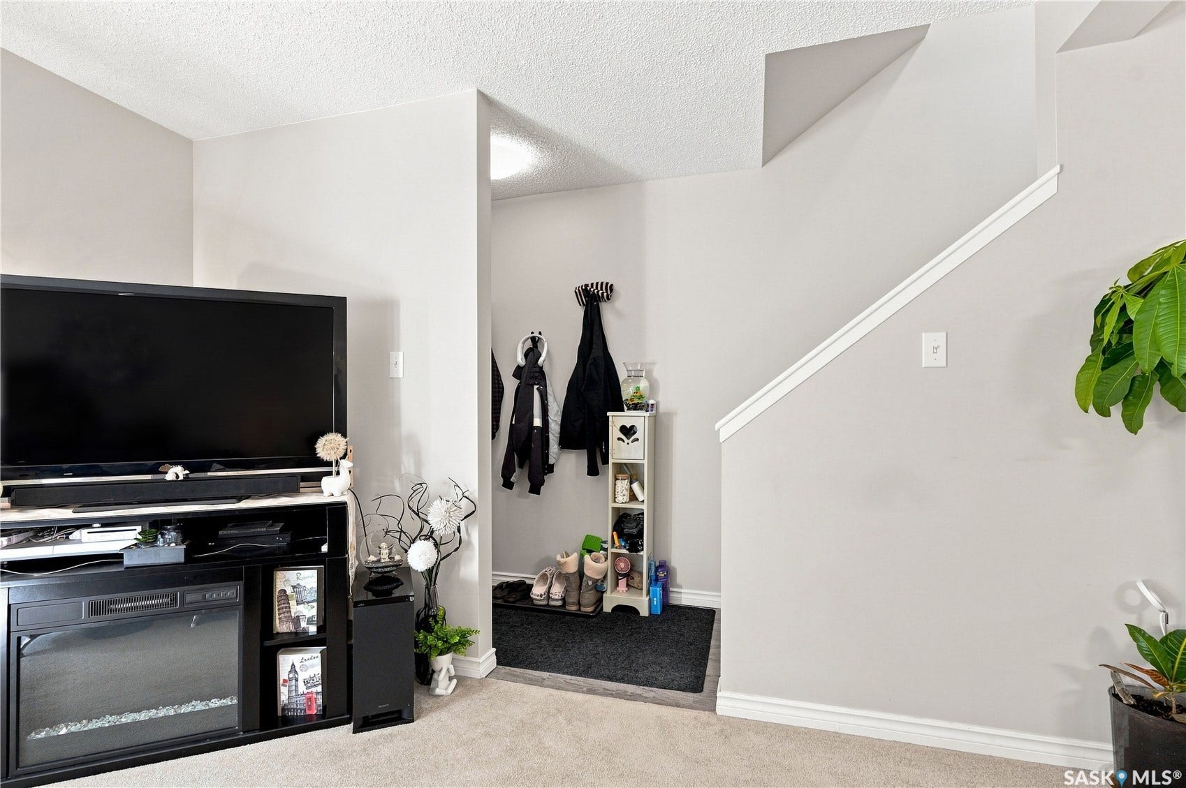 Recessed entryway with a built-in electric fireplace entertainment center, and carpeted flooring