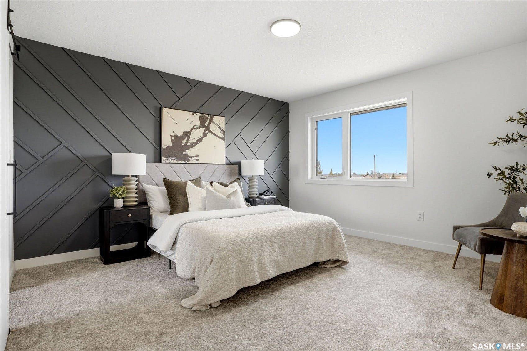 Accent wall with geometric paneling, plush carpeting, contemporary flush-mount ceiling light, white trim, and a window with white framing