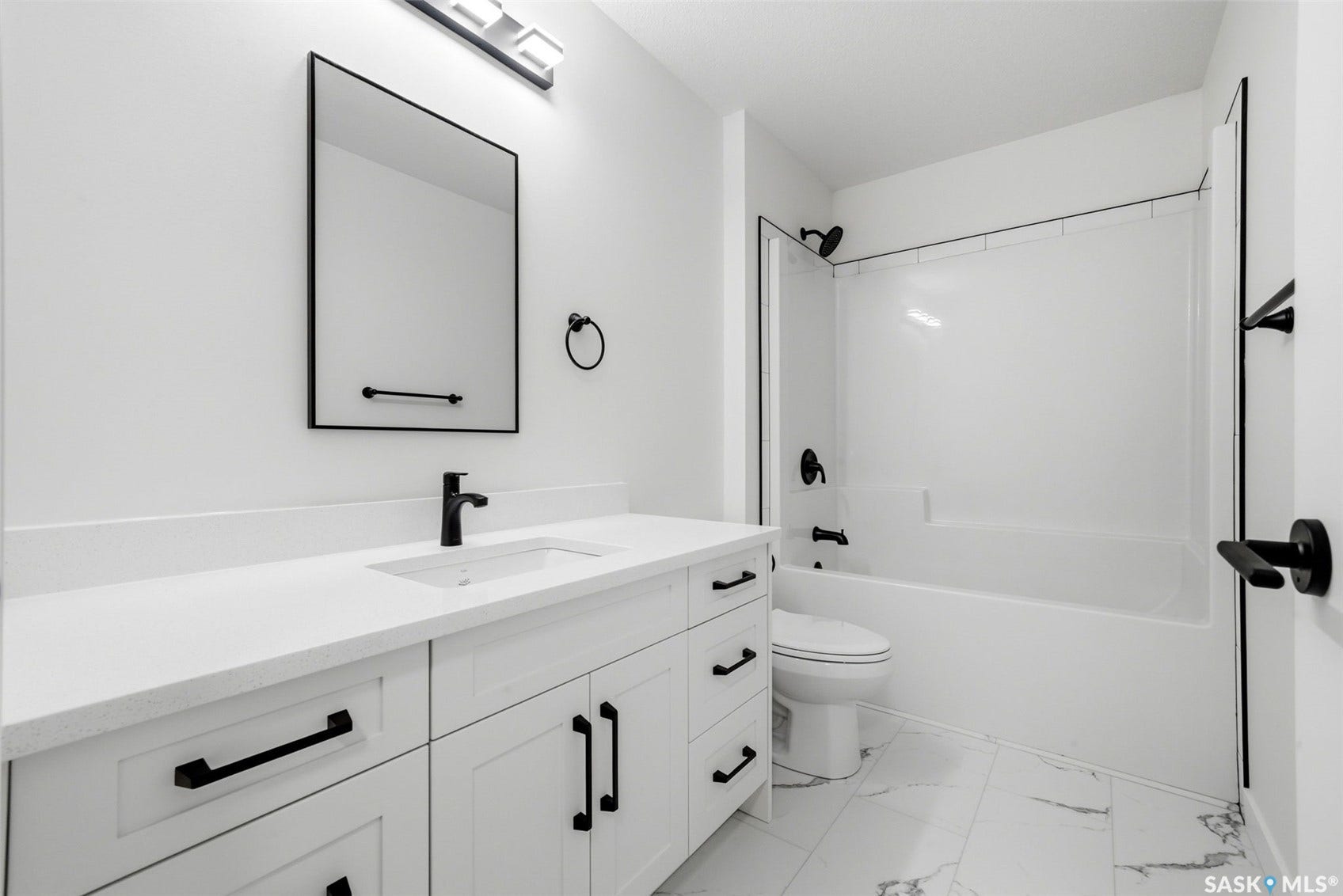 White vanity with matte black hardware, integrated sink, and white countertop