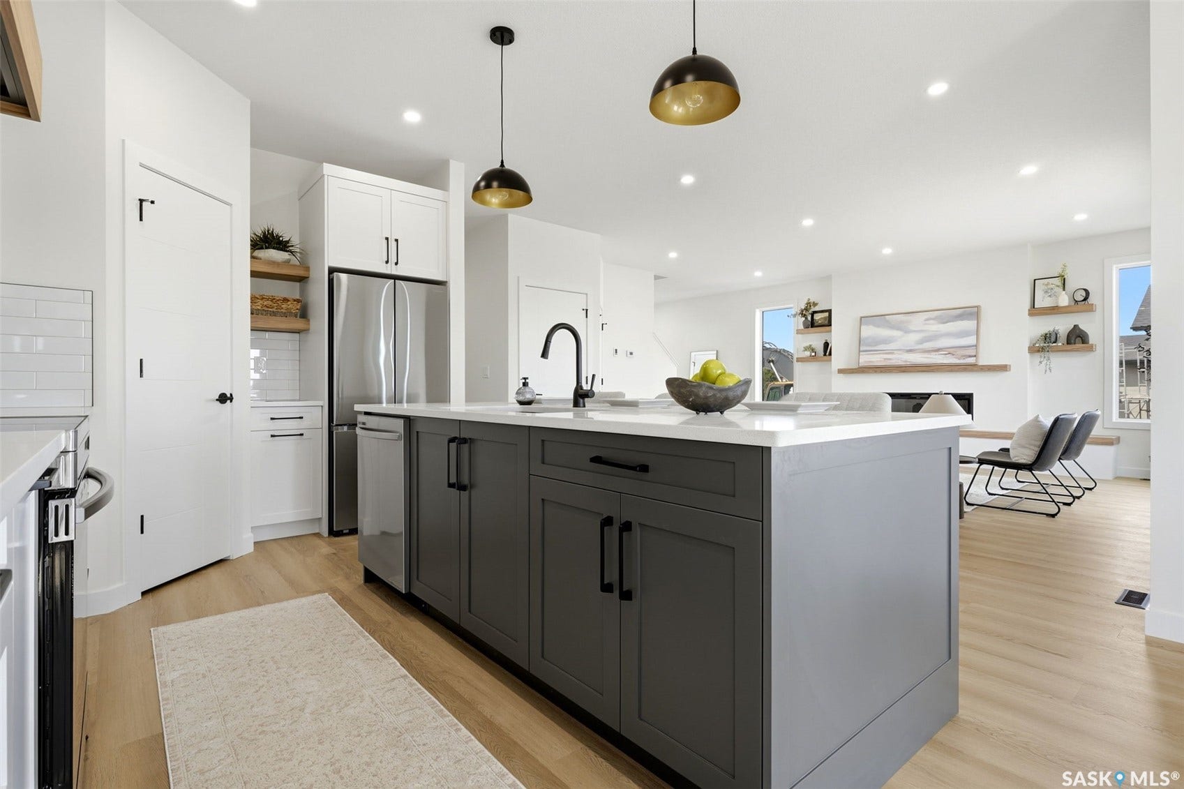 Modern kitchen featuring a large island with gray cabinetry, white countertops, and a black faucet