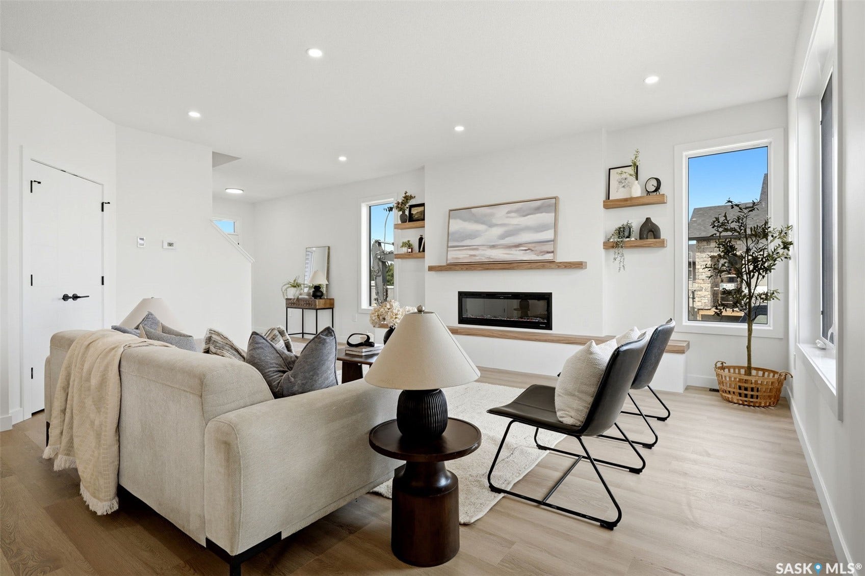Contemporary fireplace with a wood mantel, recessed lighting, wood-finish flooring, and multiple windows