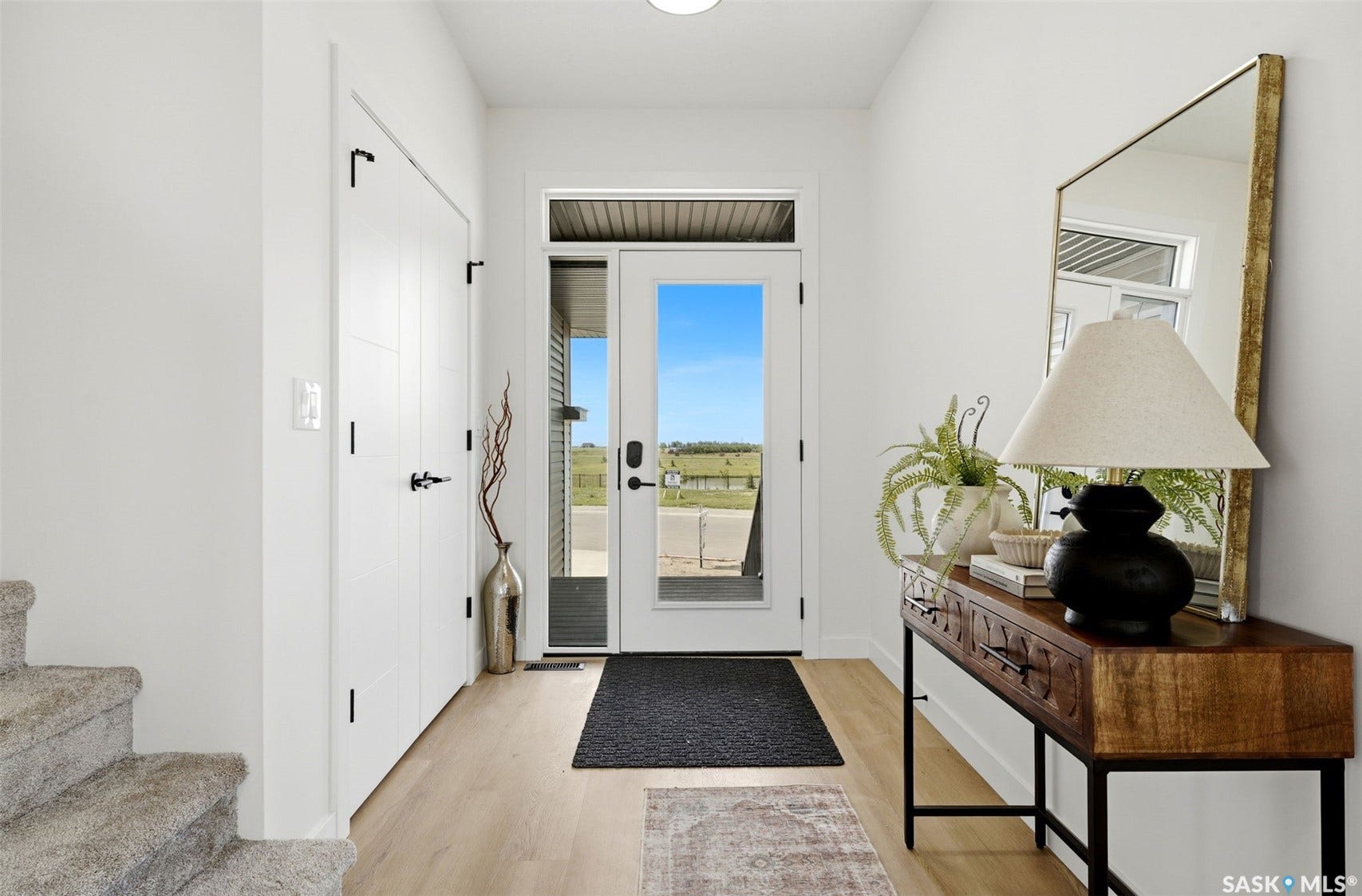 Entryway featuring light wood-finish flooring, white walls, and a glass-paneled entry door