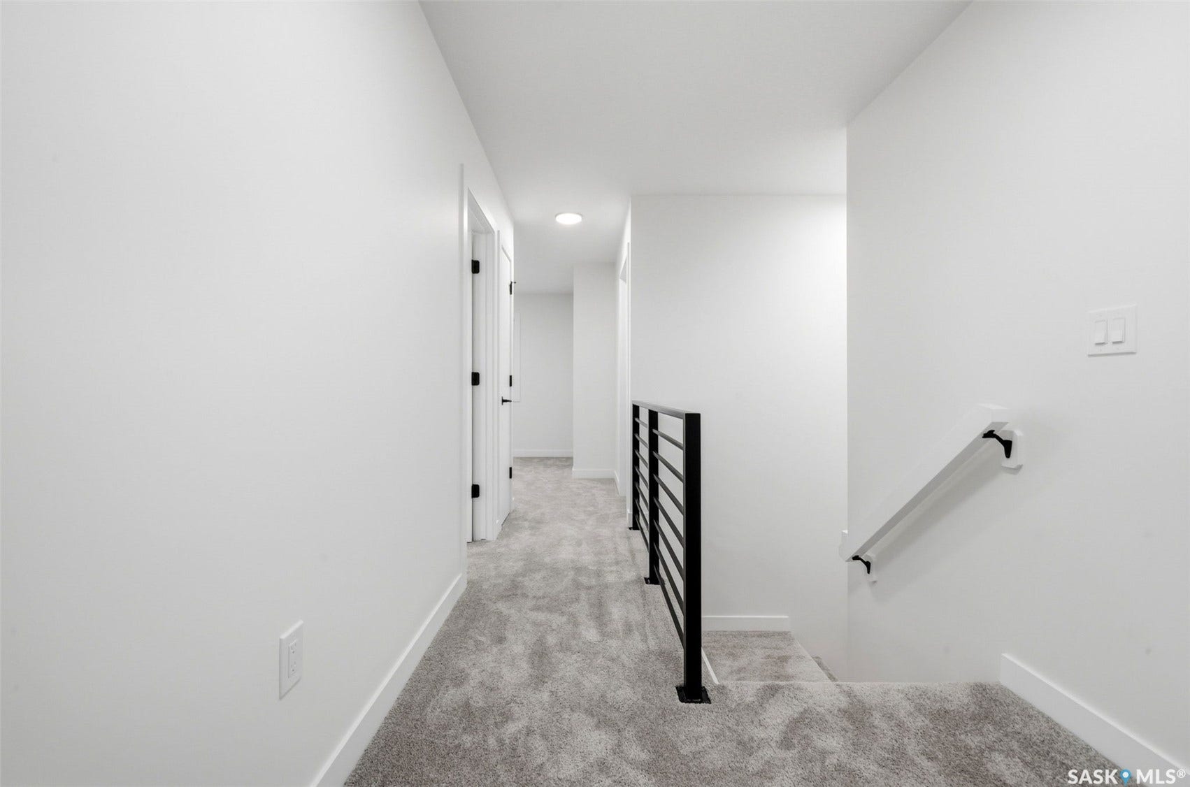 Neutral wall color, recessed lighting, carpet flooring, contemporary horizontal metal railing, and wall-mounted handrail