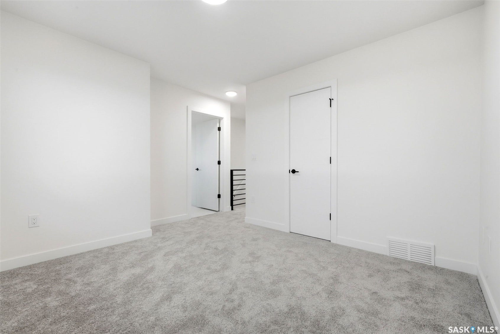 Neutral color palette, wall-to-wall carpeting, contemporary interior doors with black hardware, recessed ceiling lighting, and white baseboards