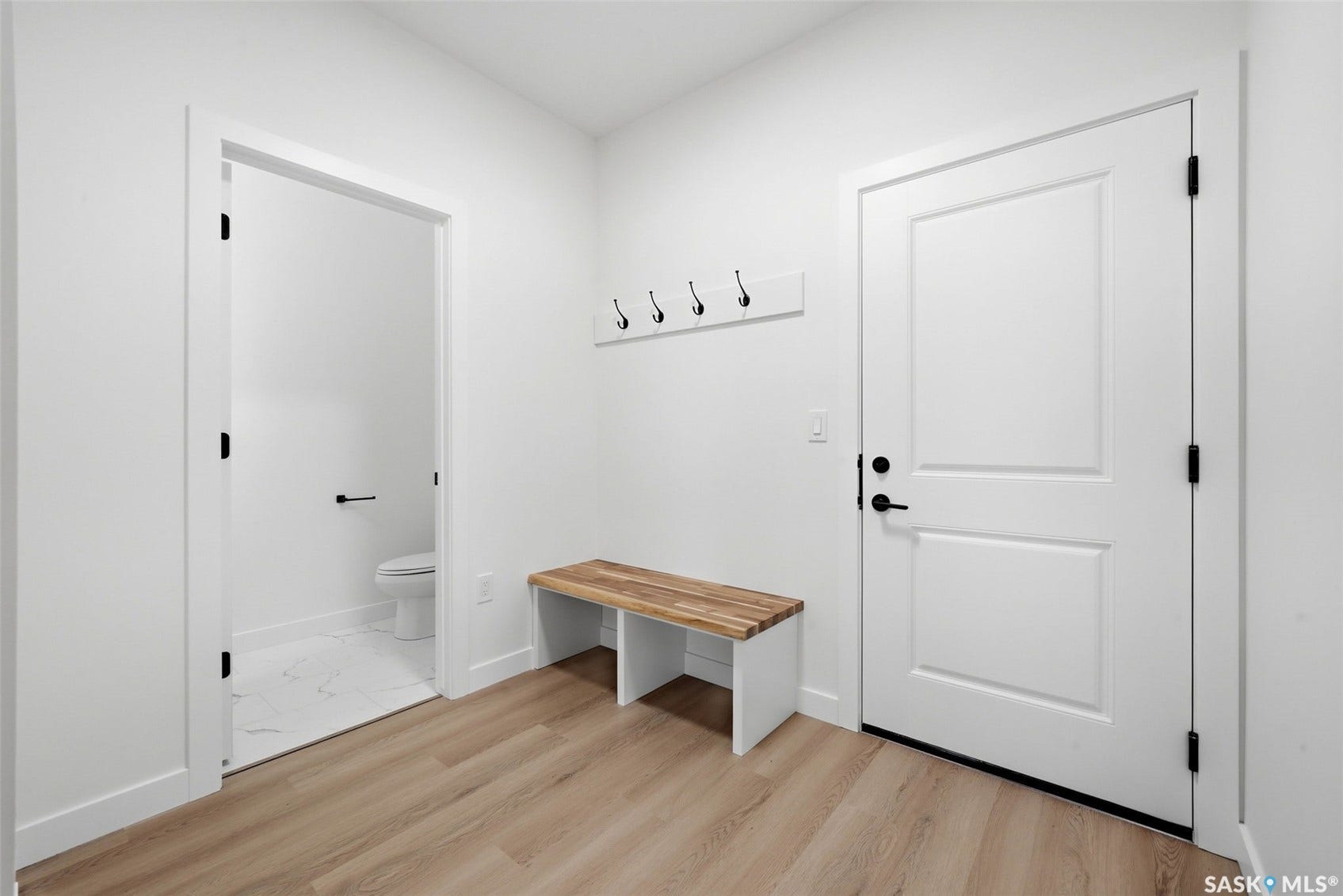 Light wood-finish flooring with white walls