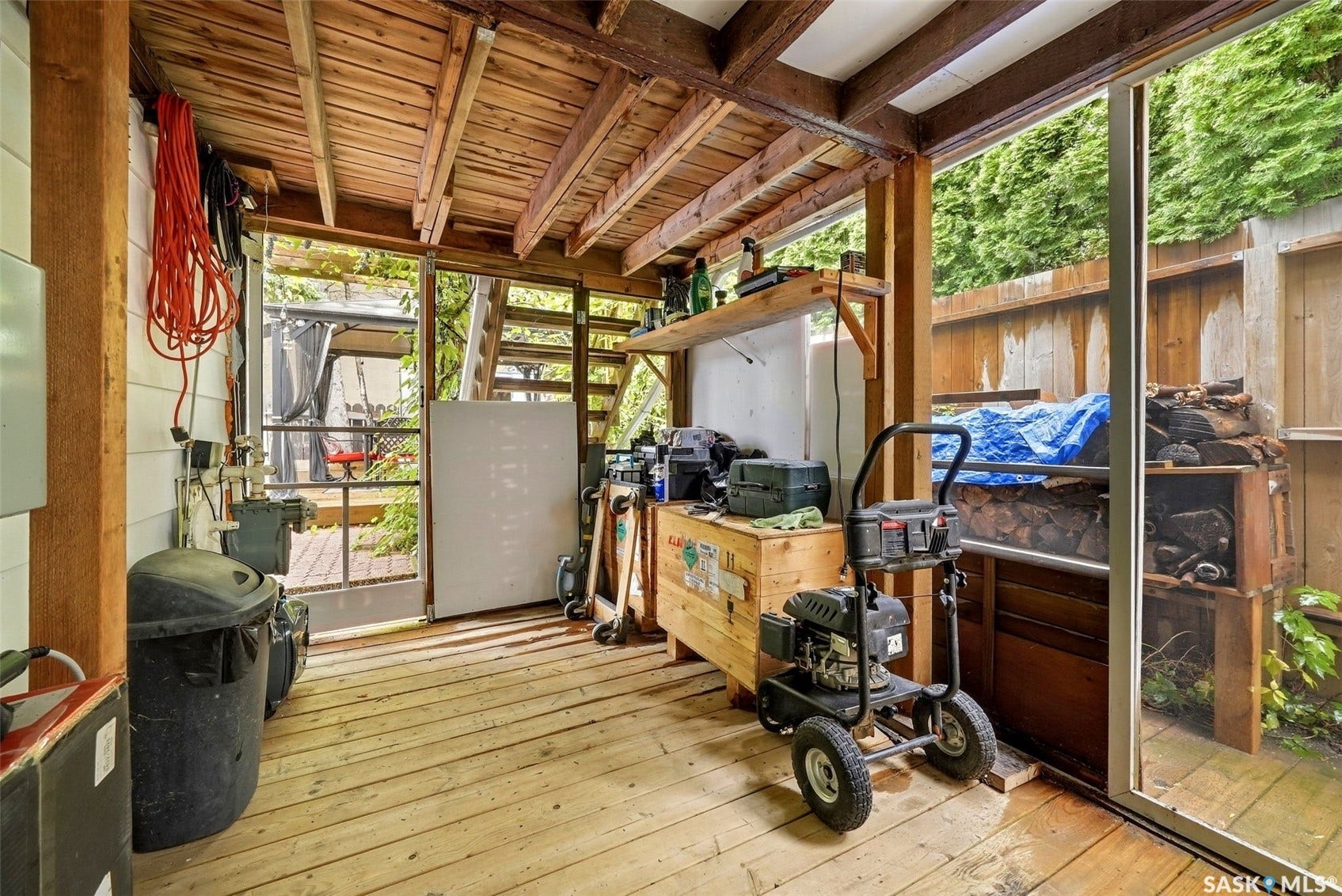 Covered outdoor space with wood decking and exposed wood beam ceiling