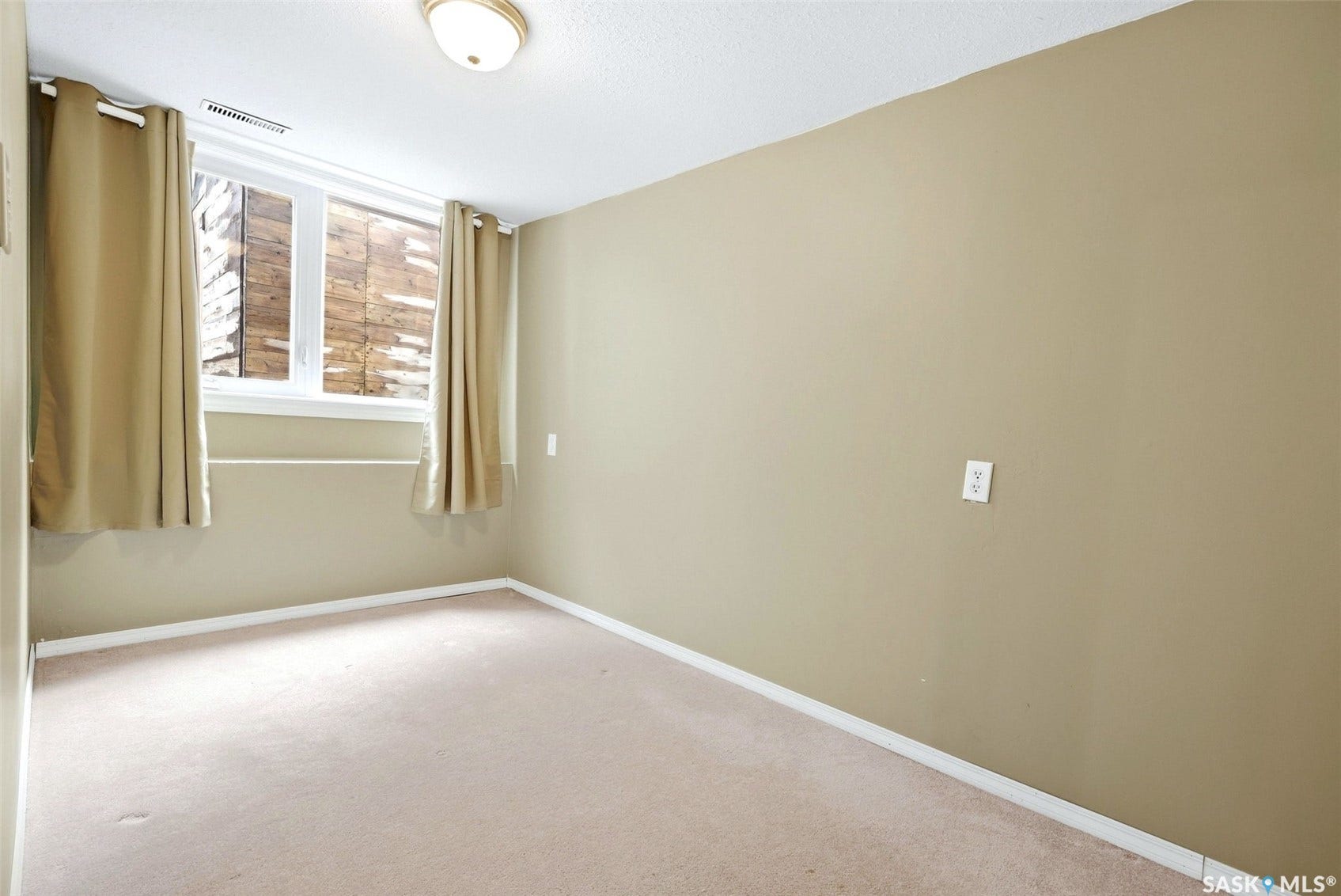 Carpeted flooring, neutral wall color, and a window with a sill
