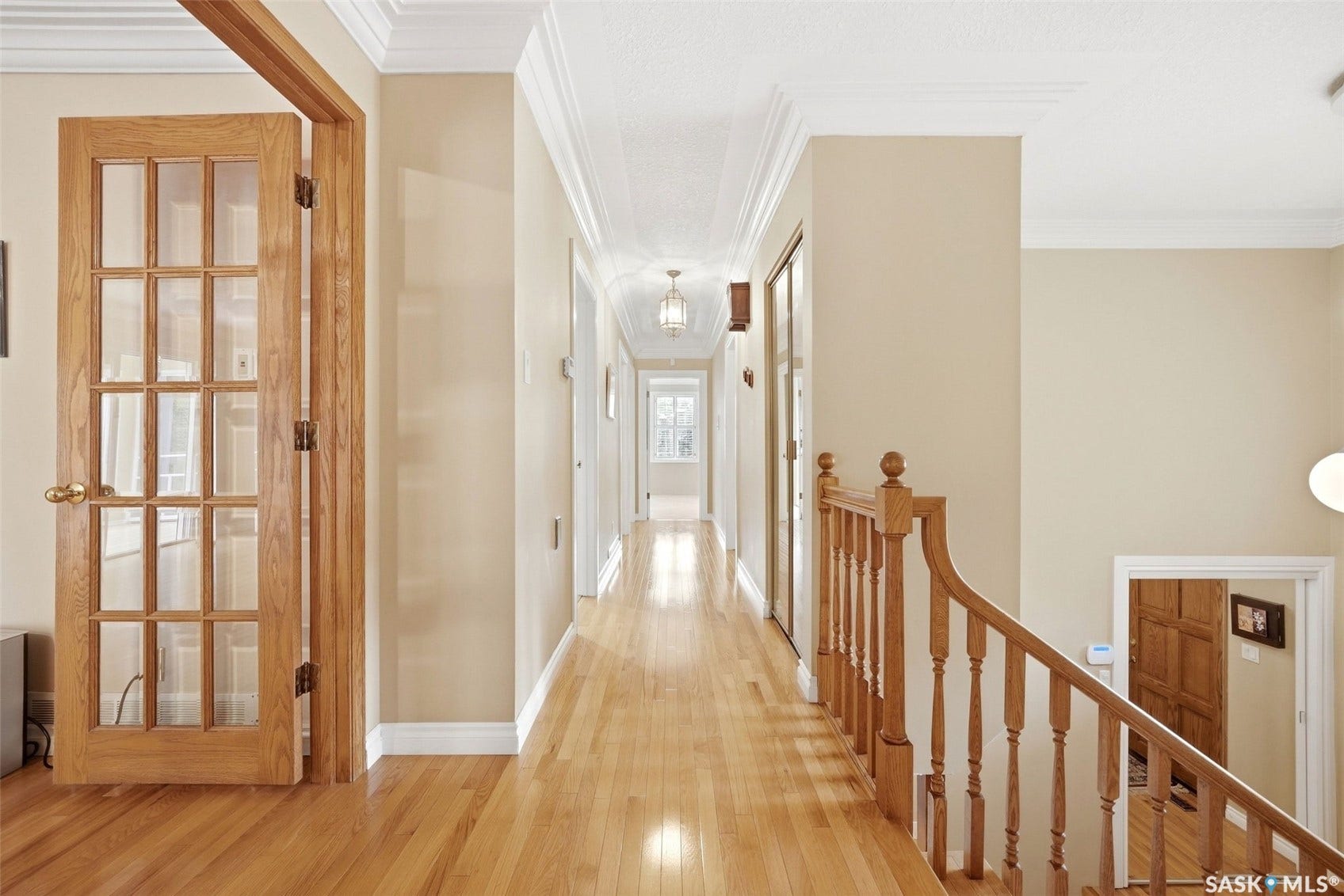 Hardwood flooring throughout, crown molding, paneled glass doors, and recessed lighting