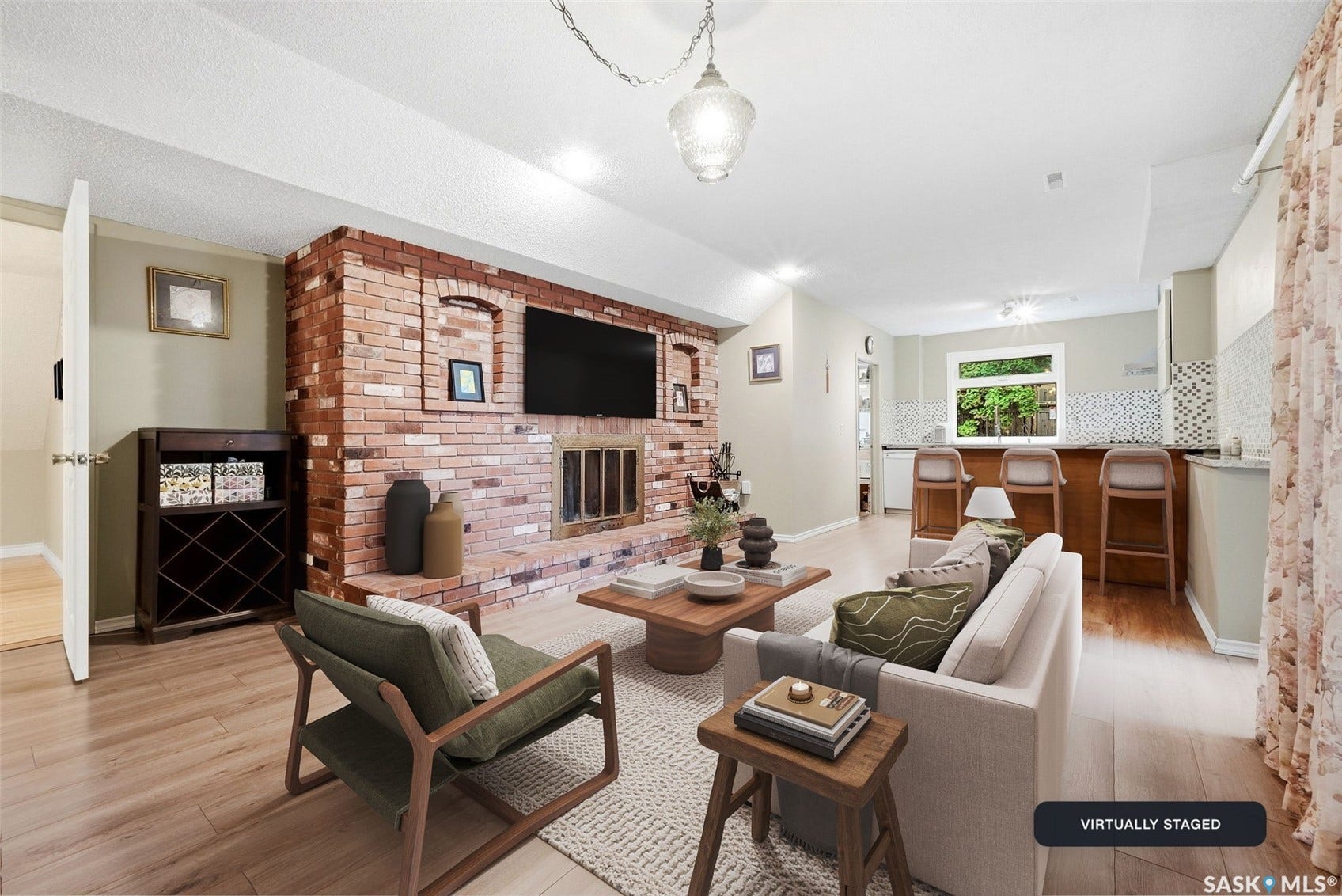 Exposed brick fireplace, wood-finish flooring, recessed lighting, built-in bar, and mosaic tile backsplash