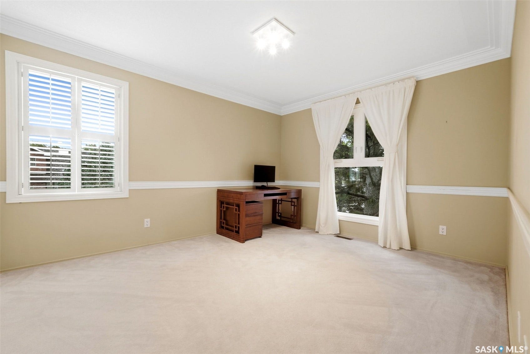 Neutral wall paint, crown molding, chair rail, window with plantation shutters, and recessed ceiling lighting