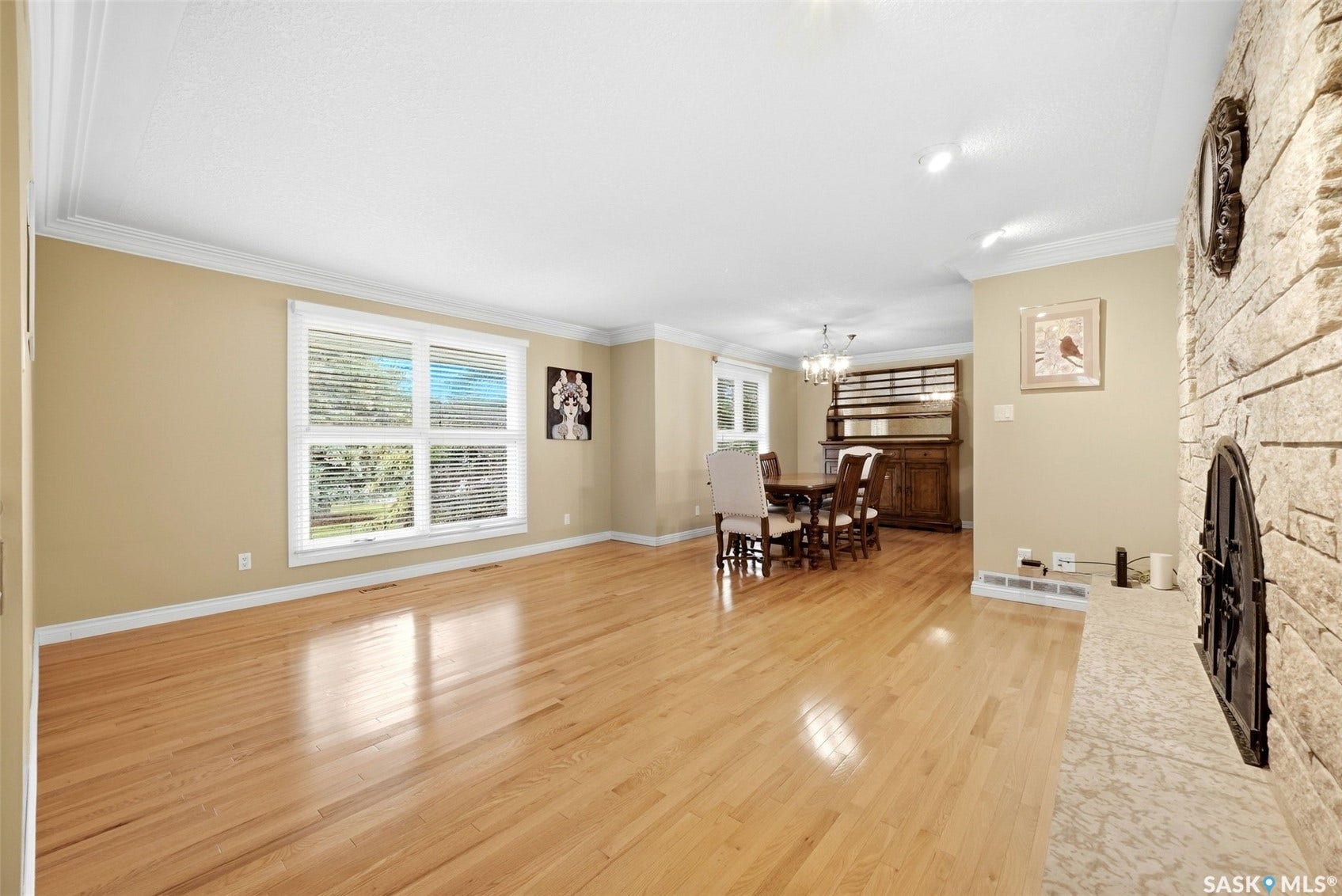Hardwood flooring throughout, crown molding, and a stone-clad fireplace