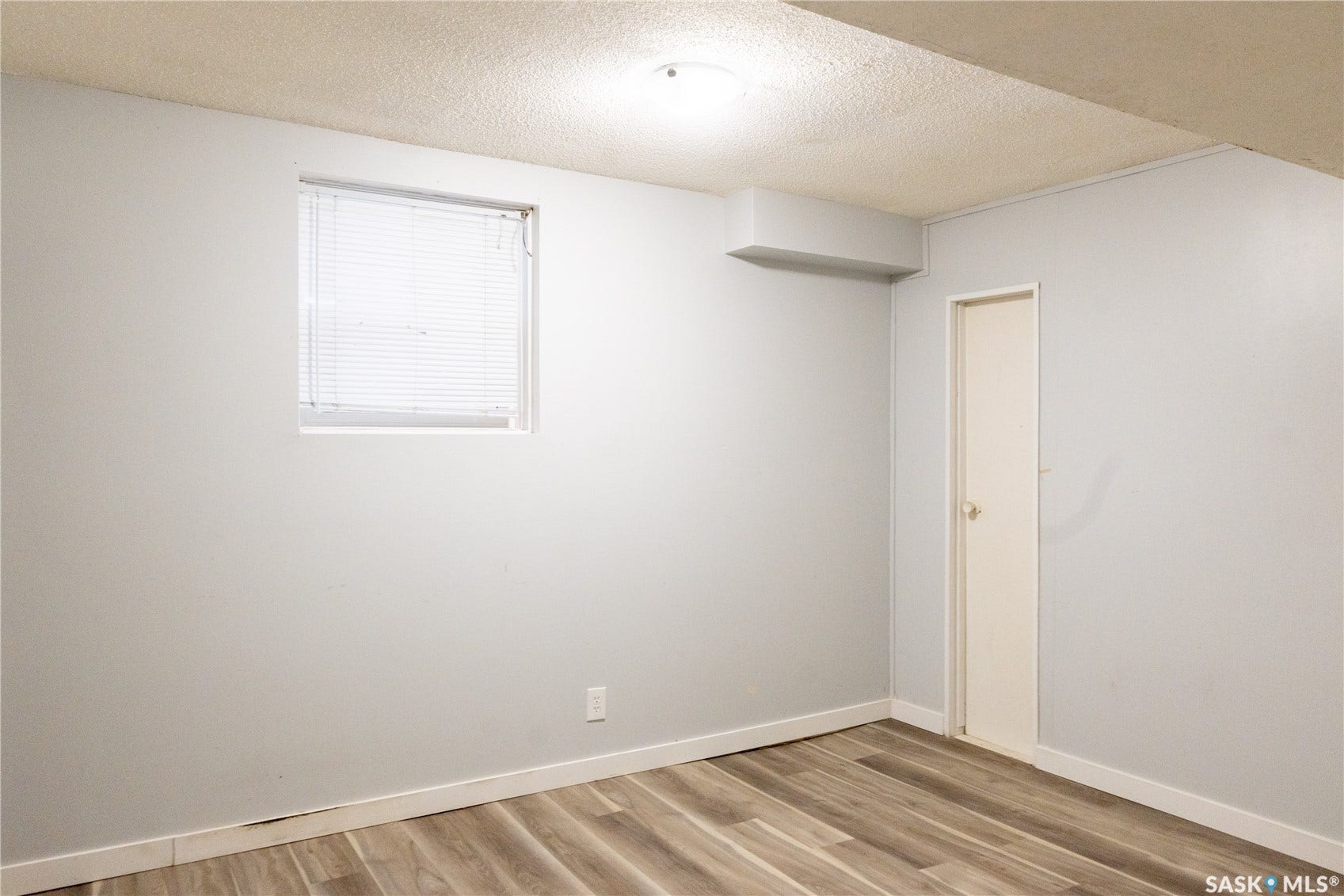 2232 McAra Street, Regina SK S4N 2W1 Wood-finish flooring, light gray wall paint, and a window with blinds
