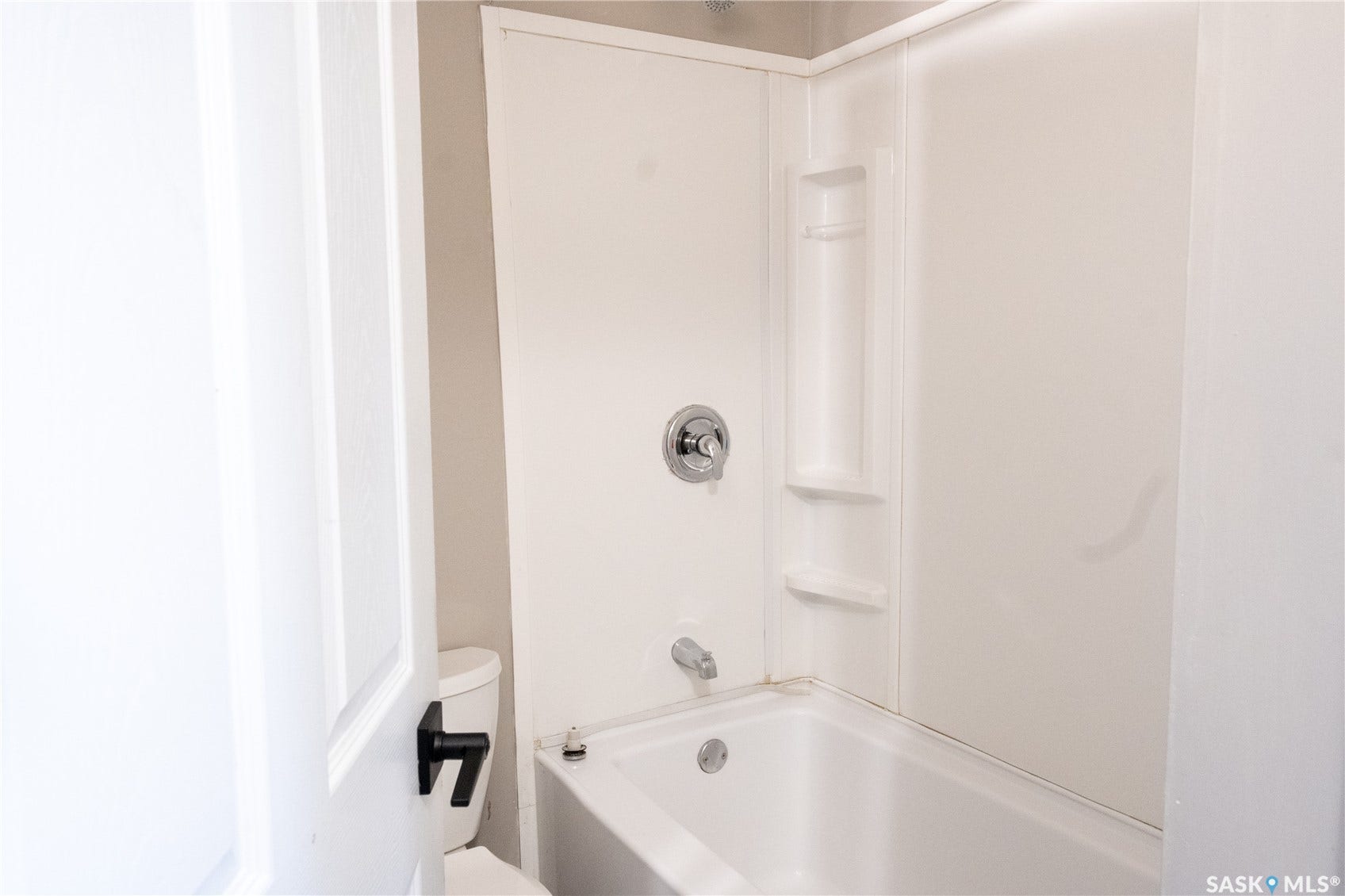2232 McAra Street, Regina SK S4N 2W1 White acrylic tub and shower combination with chrome fixtures and built-in shelving