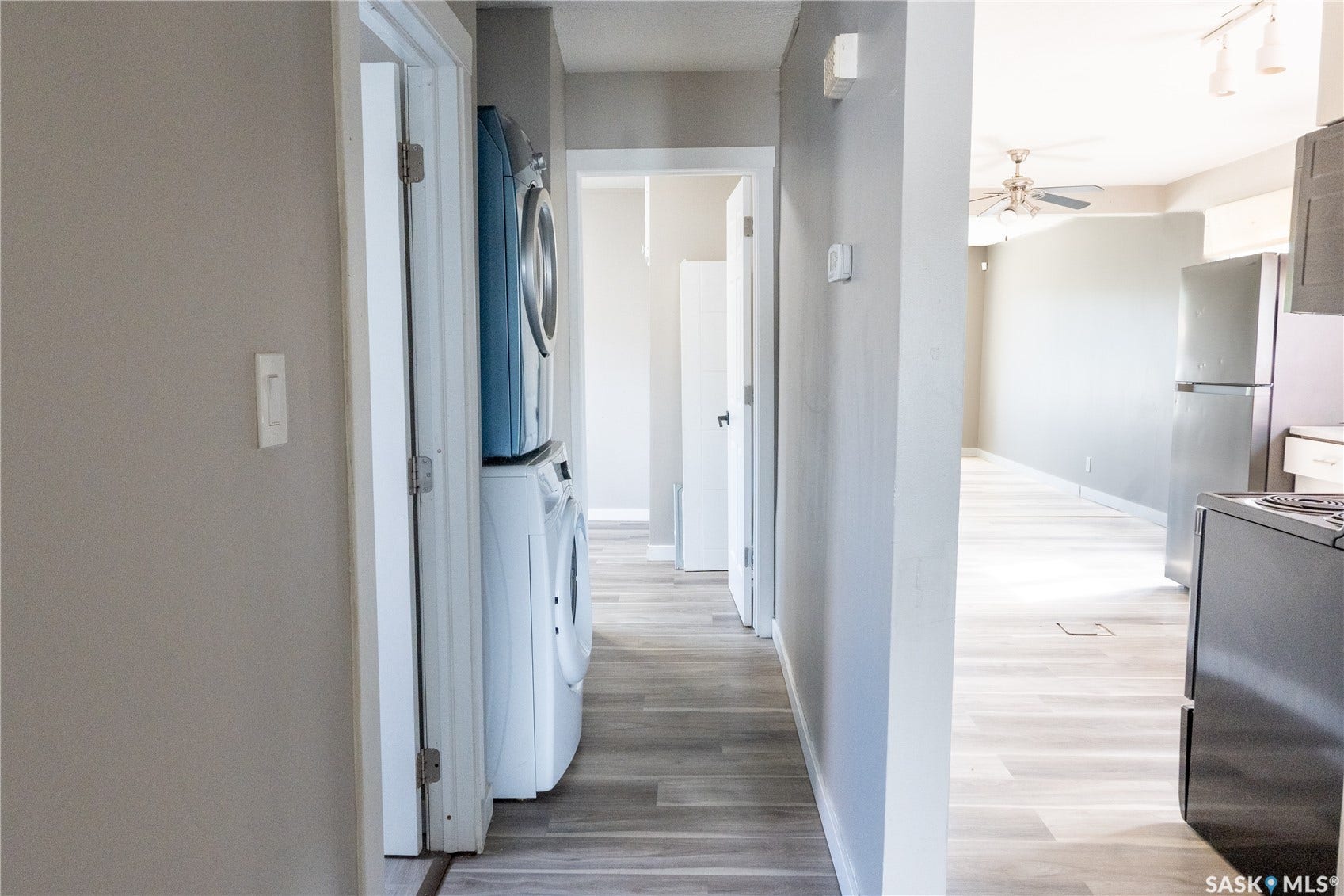 2232 McAra Street, Regina SK S4N 2W1 Stackable washer and dryer, wood-finish flooring, stainless steel refrigerator, dark finish range, and ceiling fan