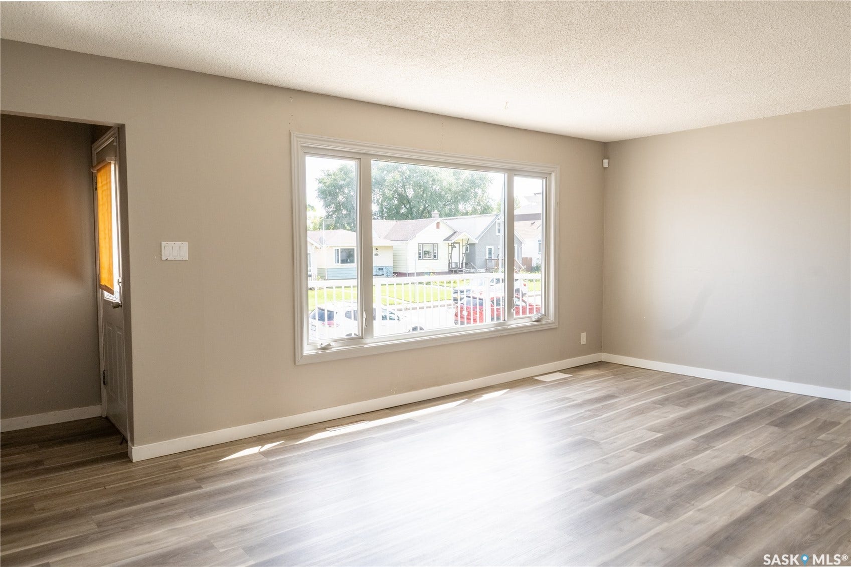 2232 McAra Street, Regina SK S4N 2W1 Wood-finish flooring, neutral wall tones, white trim, and a large multi-pane window
