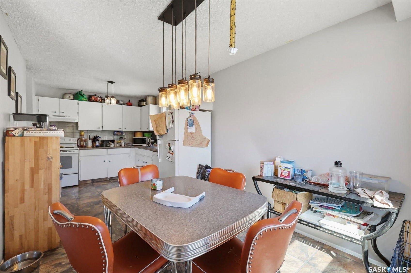 White cabinetry, recessed lighting, and a modern linear chandelier