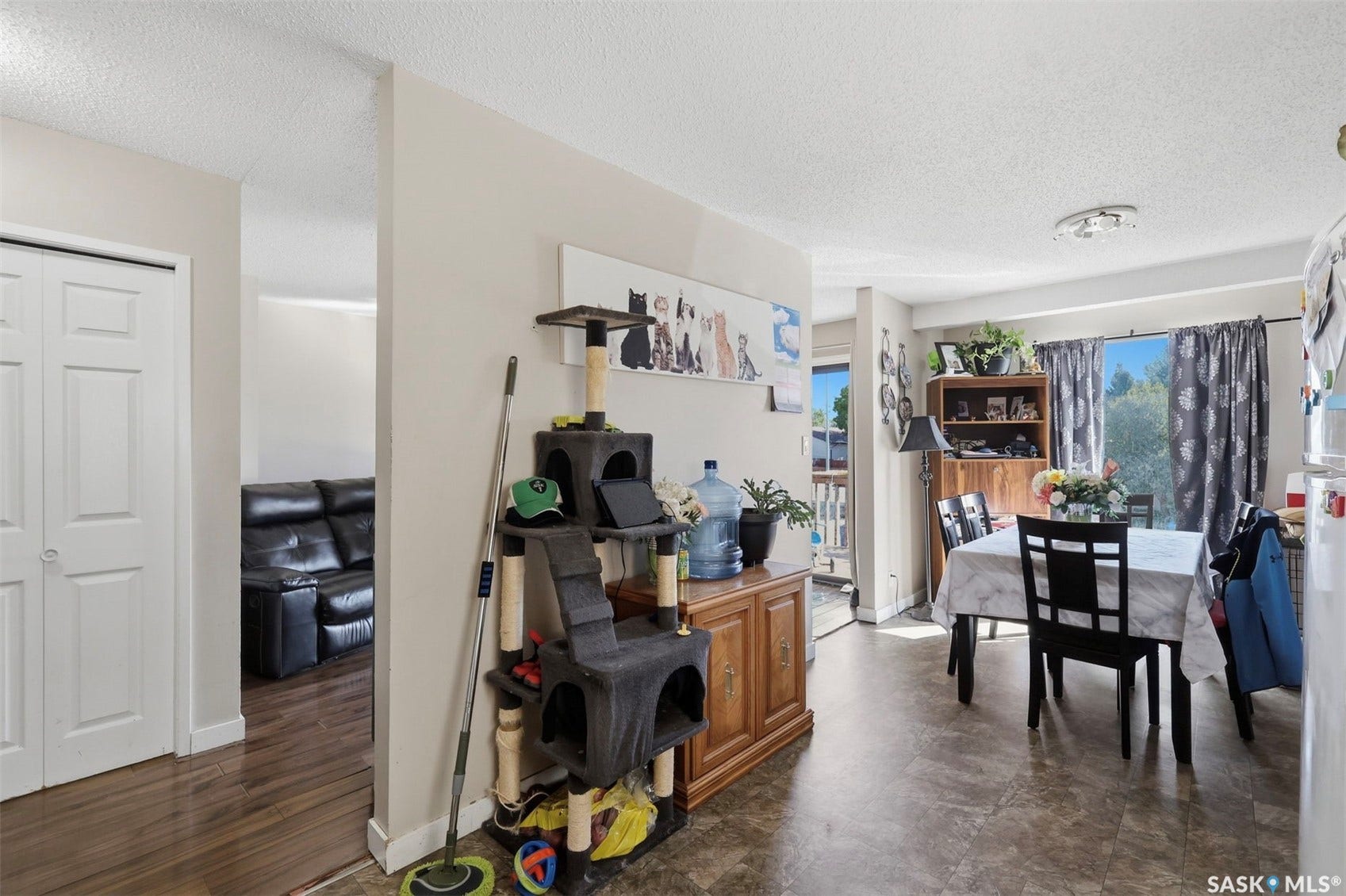 Combined living and dining area with varied flooring, featuring a dining space with a window