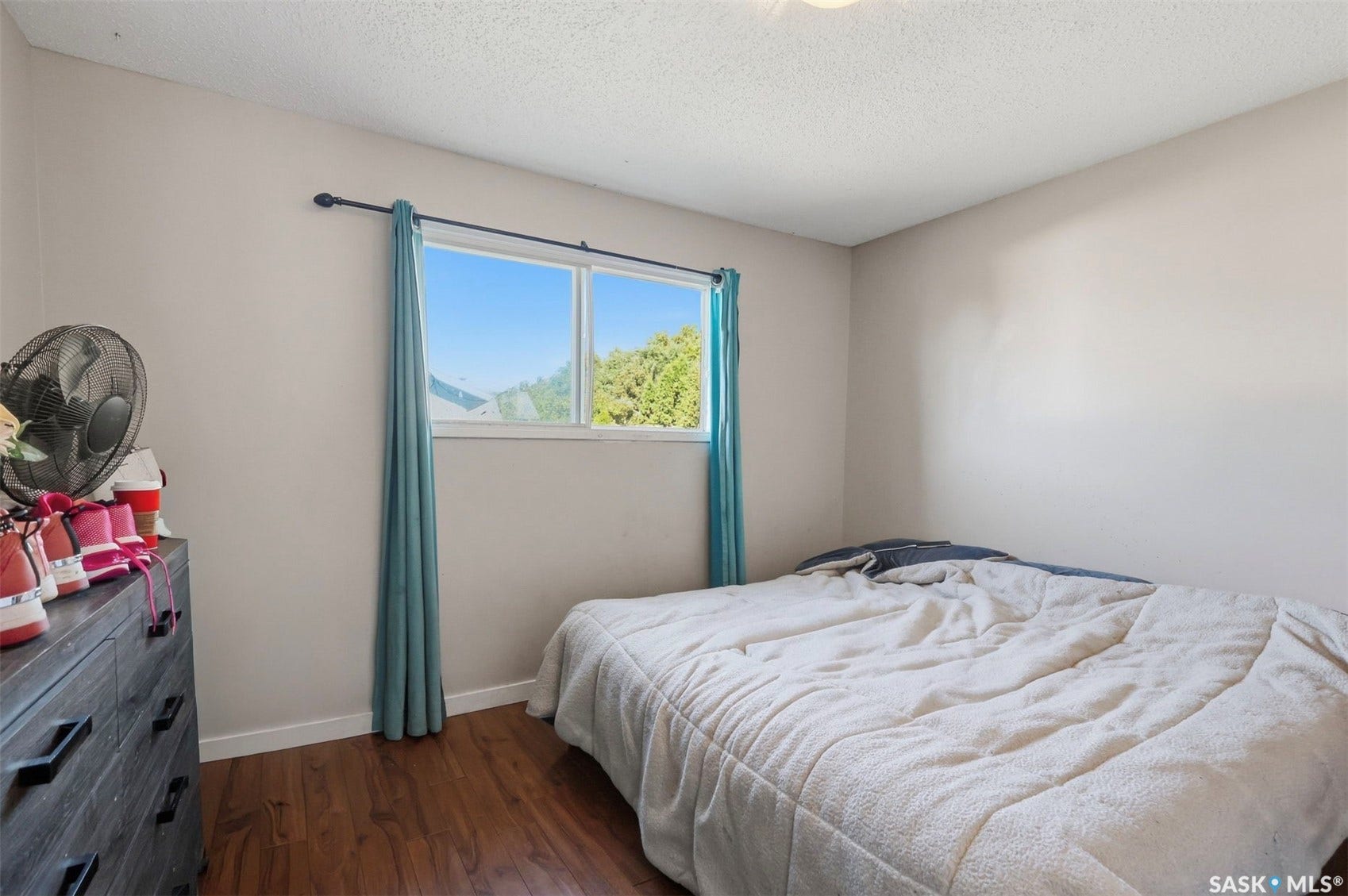 Wood-finish flooring with neutral wall paint and a single window
