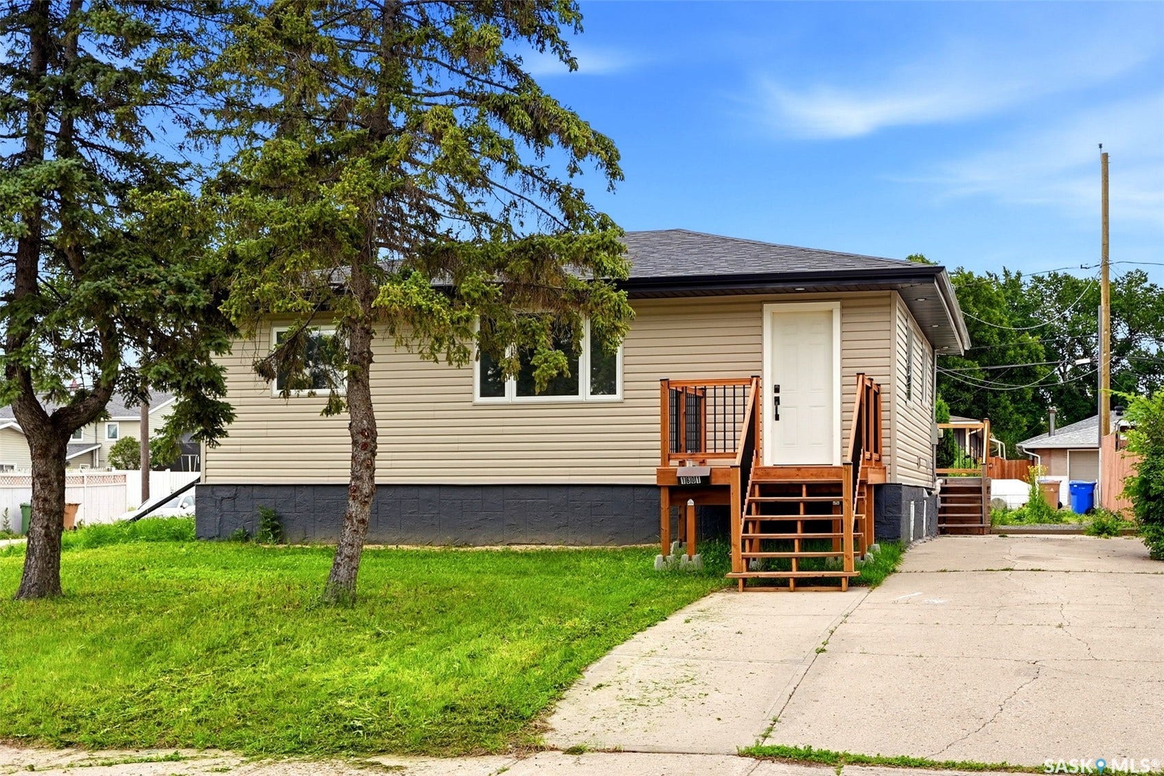 1601 Lacon Street, Regina SK S4N 1Z5 Beige horizontal siding exterior with a dark roof and a concrete driveway