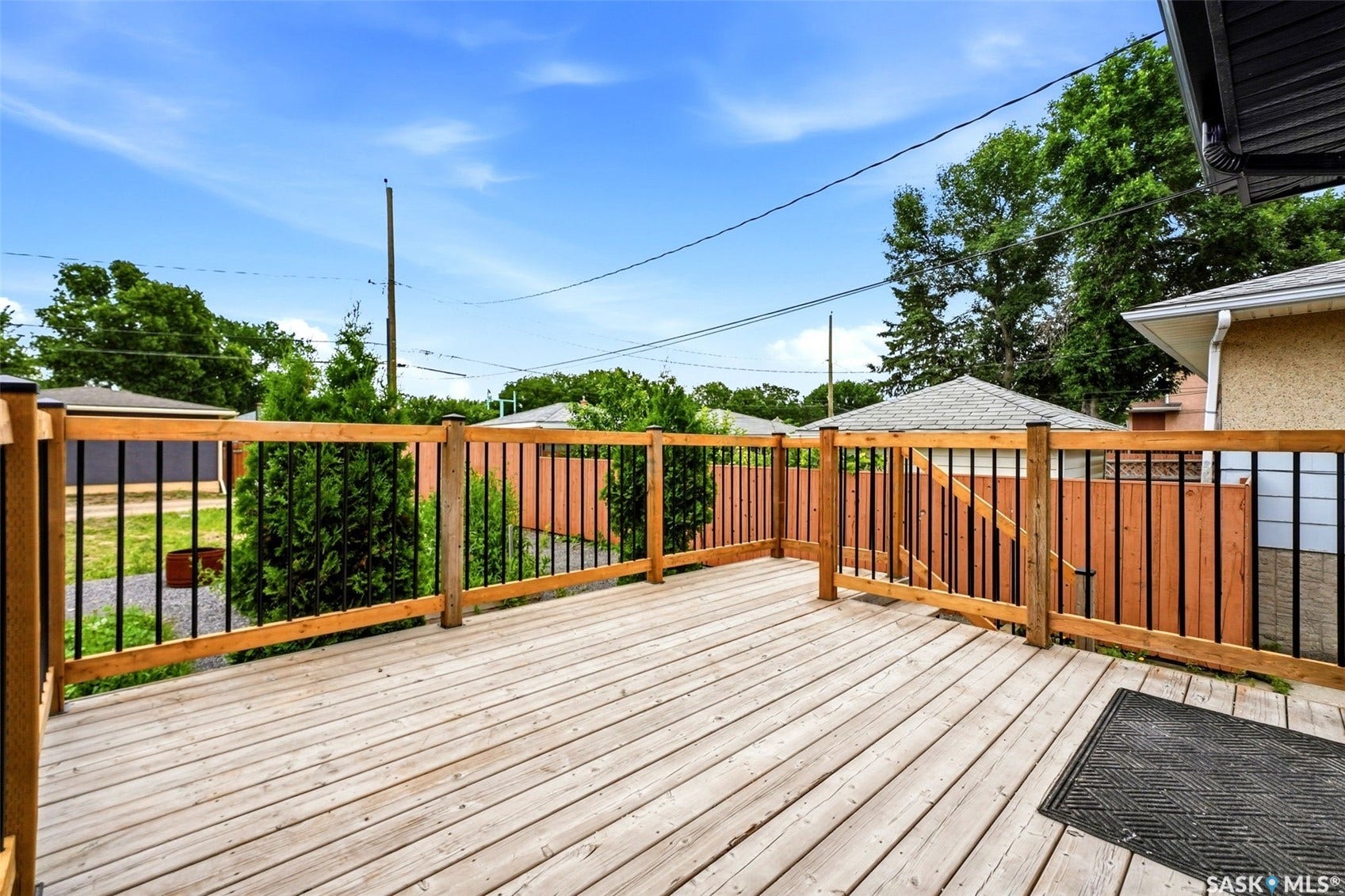 1601 Lacon Street, Regina SK S4N 1Z5 Expansive wood deck with a natural finish, featuring a wood and black metal railing