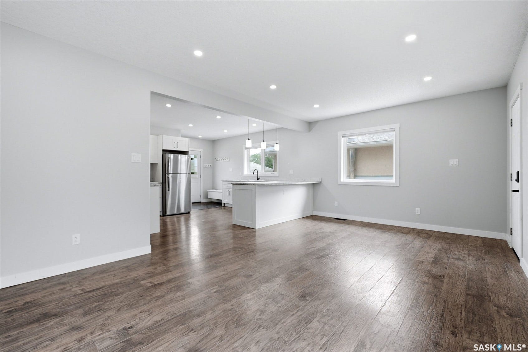 1601 Lacon Street, Regina SK S4N 1Z5 Open-concept living space featuring wood-finish flooring, recessed lighting, and a white kitchen island
