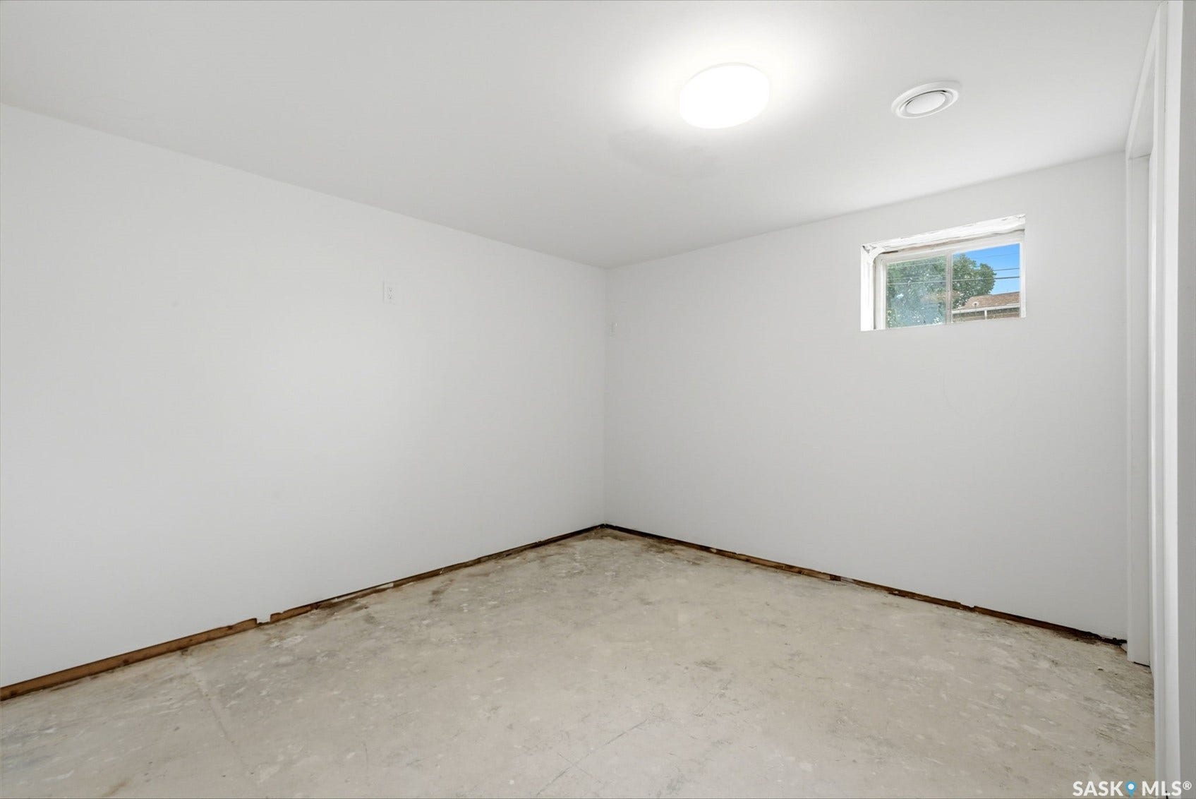1601 Lacon Street, Regina SK S4N 1Z5 White painted walls, concrete flooring, and a single window