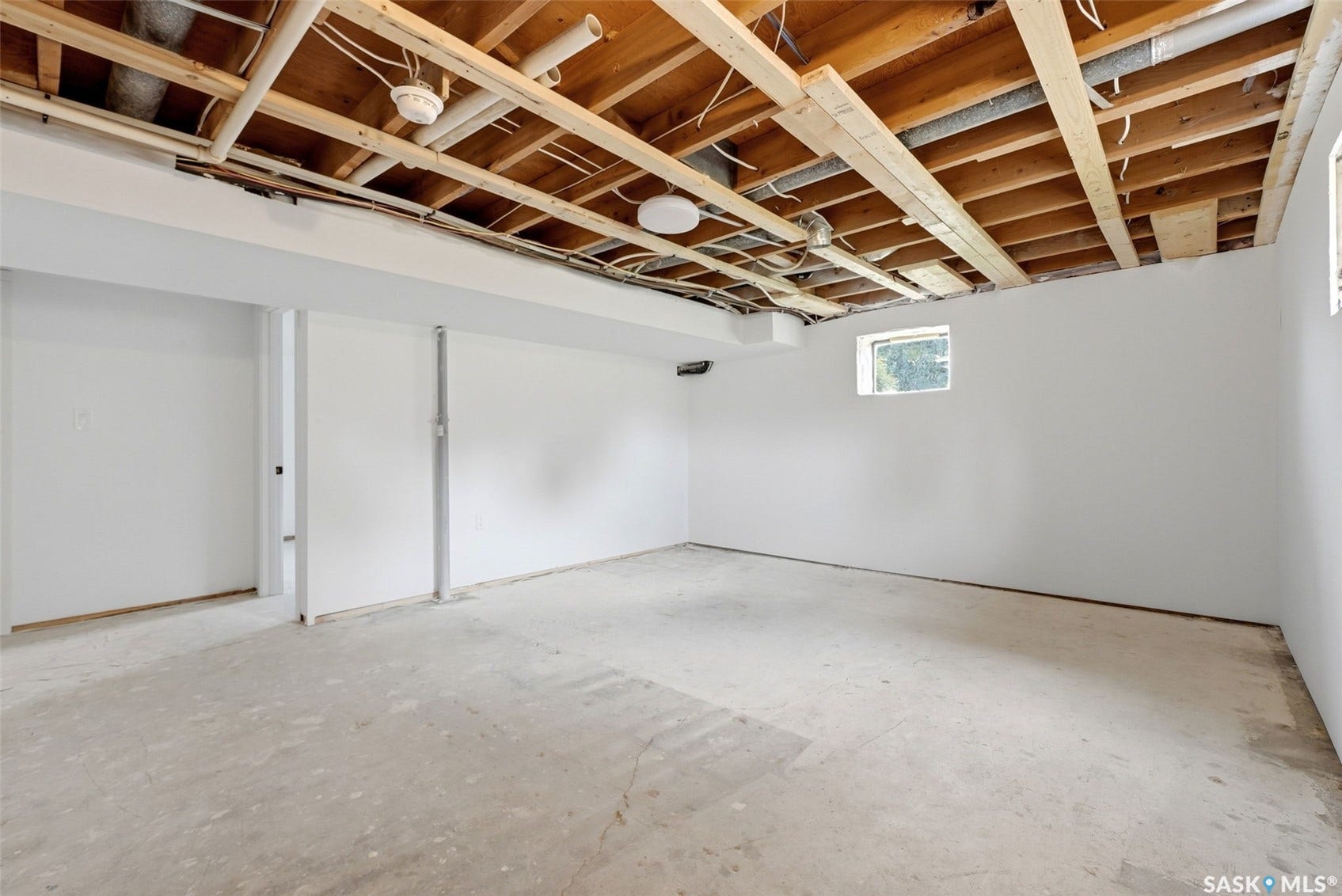 1601 Lacon Street, Regina SK S4N 1Z5 Unfinished basement featuring exposed ceiling joists, concrete flooring, and white painted walls