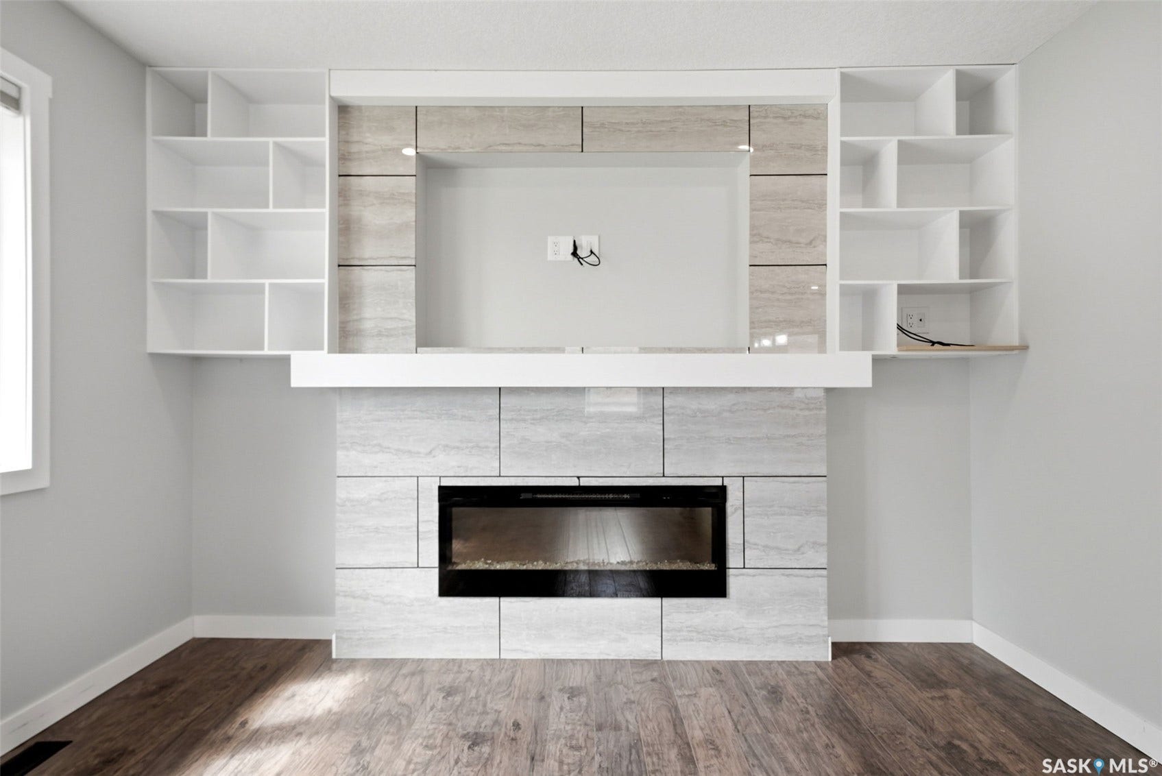 1601 Lacon Street, Regina SK S4N 1Z5 Built-in shelving units, an integrated fireplace, wood-finish flooring, and a tiled fireplace surround