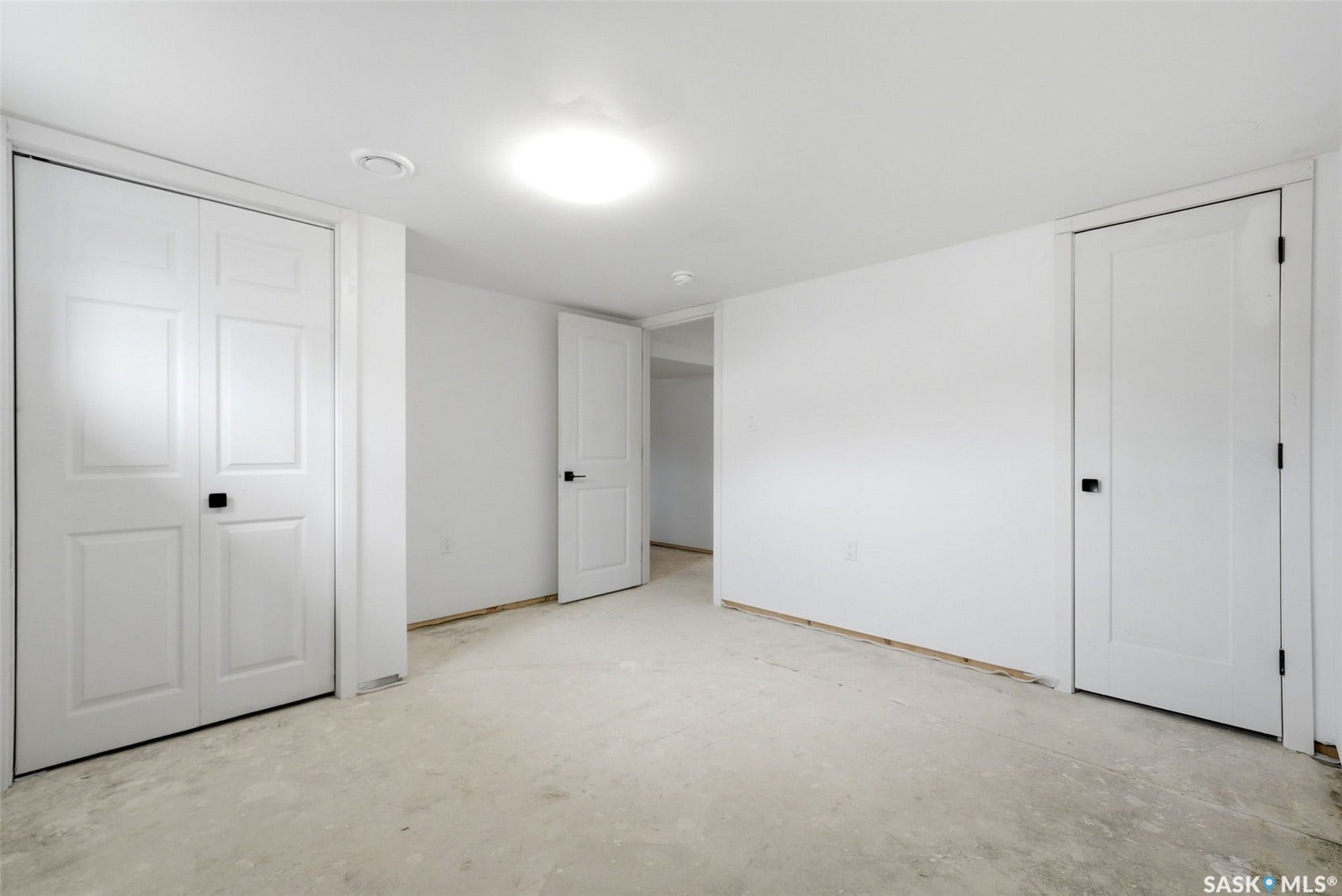 1601 Lacon Street, Regina SK S4N 1Z5 Bright interior with white walls, a flush-mount ceiling light, and white paneled doors with black hardware