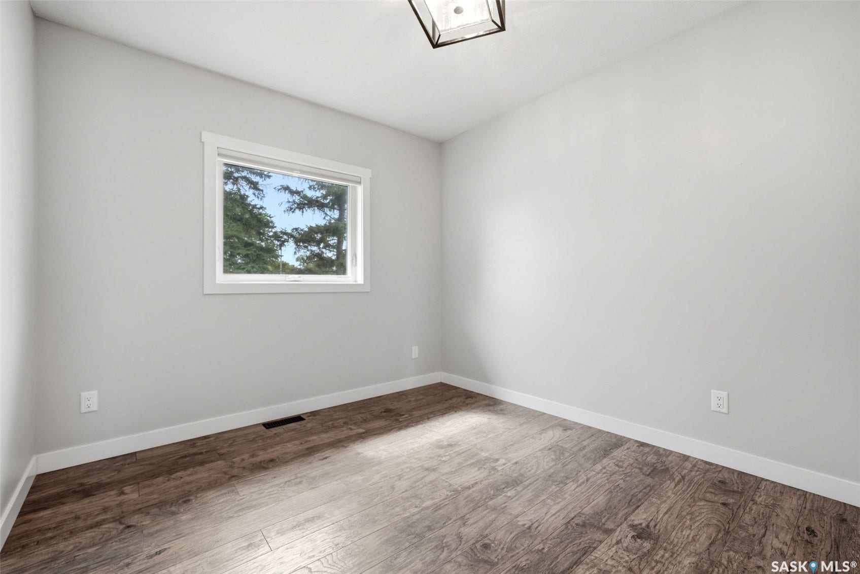 1601 Lacon Street, Regina SK S4N 1Z5 Neutral wall color, wood-finish flooring, white trim, and a window with white casing