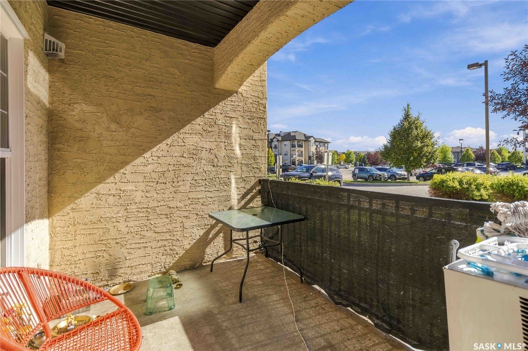Private balcony with textured stucco walls, concrete flooring, and a privacy screen