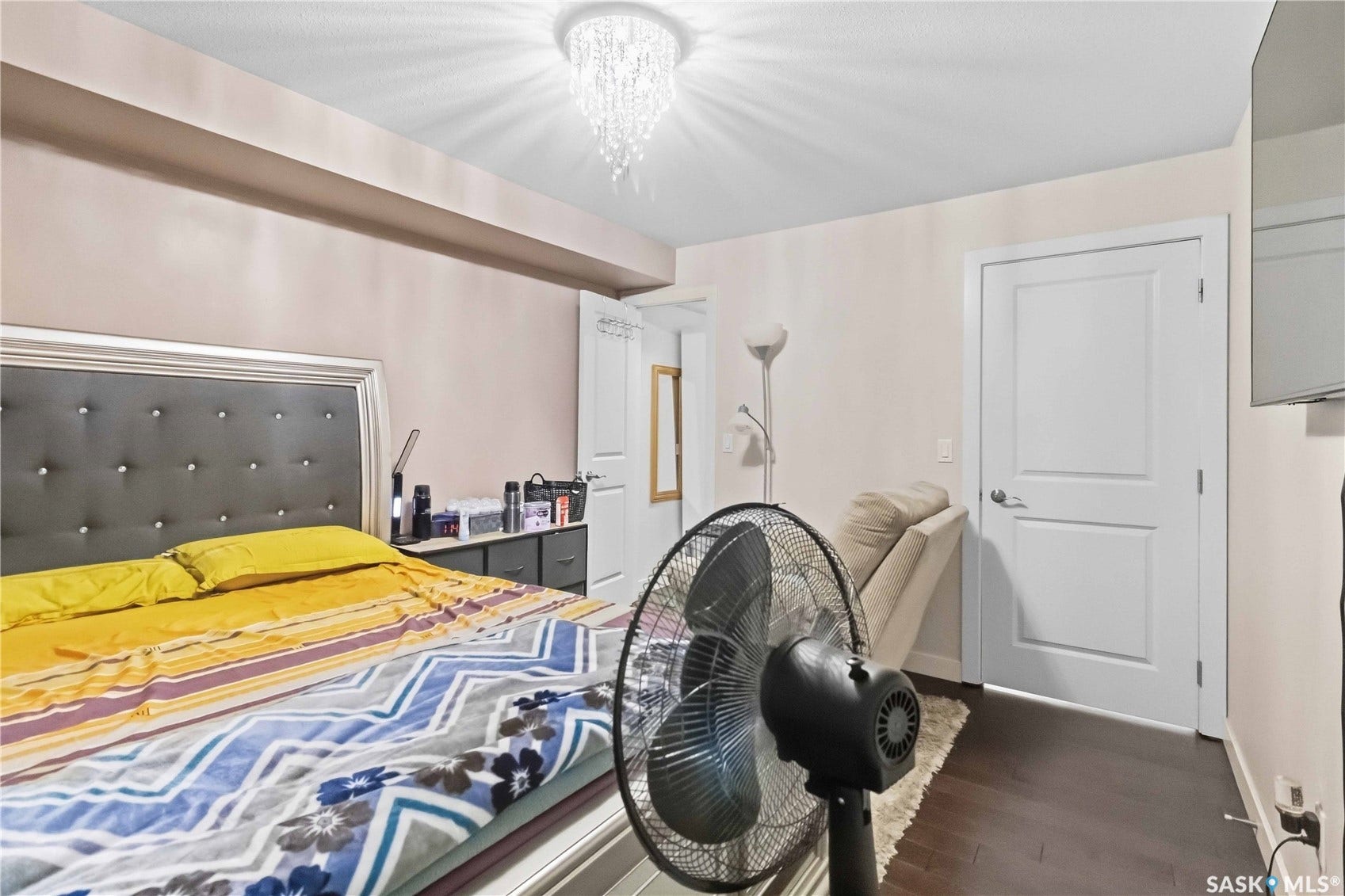 Dark wood-finish flooring, white two-panel door, and a decorative ceiling light fixture