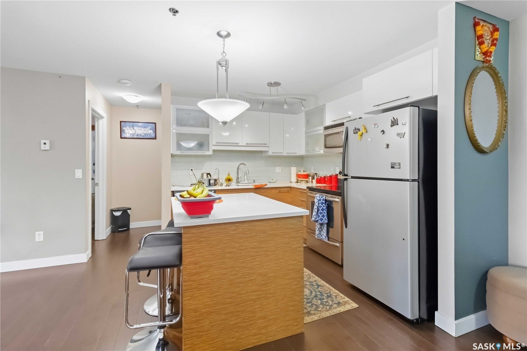 Kitchen with wood-finish flooring, a central island with countertop, and stainless steel appliances
